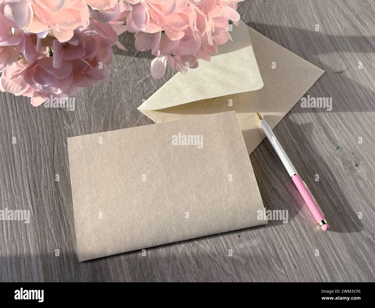 Ein Stück Papier auf einem Holztisch. Kopierraum auf leerer Grußkarte. Stockfoto