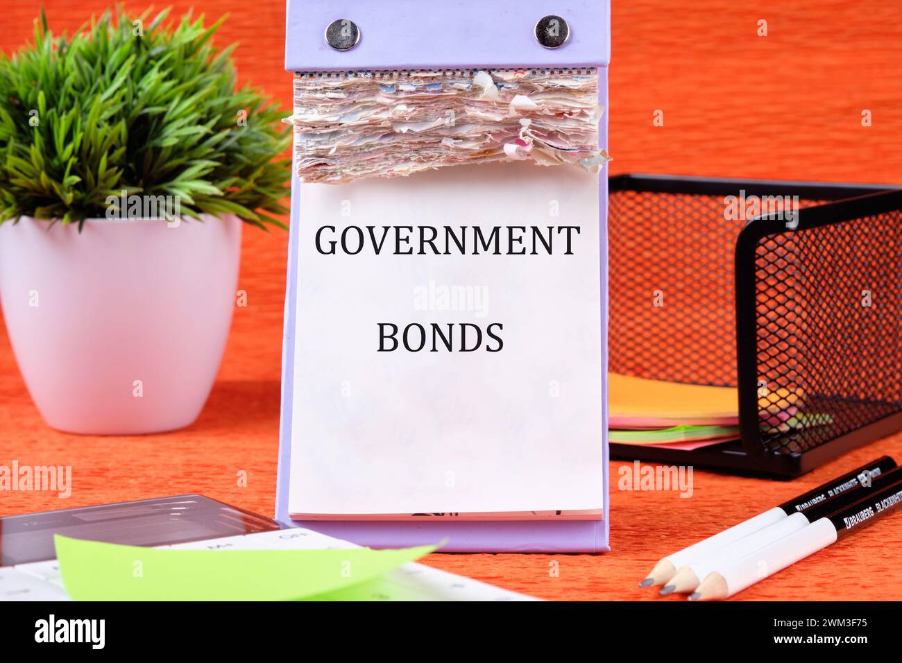 Text für Staatsanleihen auf der Seite des Desktop-Kalenders auf orangefarbenem Hintergrund Stockfoto