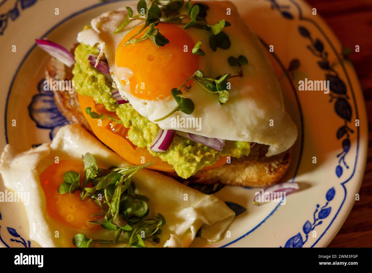 Sehr lecker aussehender Toast mit Rührei mit Tomaten, Salat und Avocadodressing Stockfoto