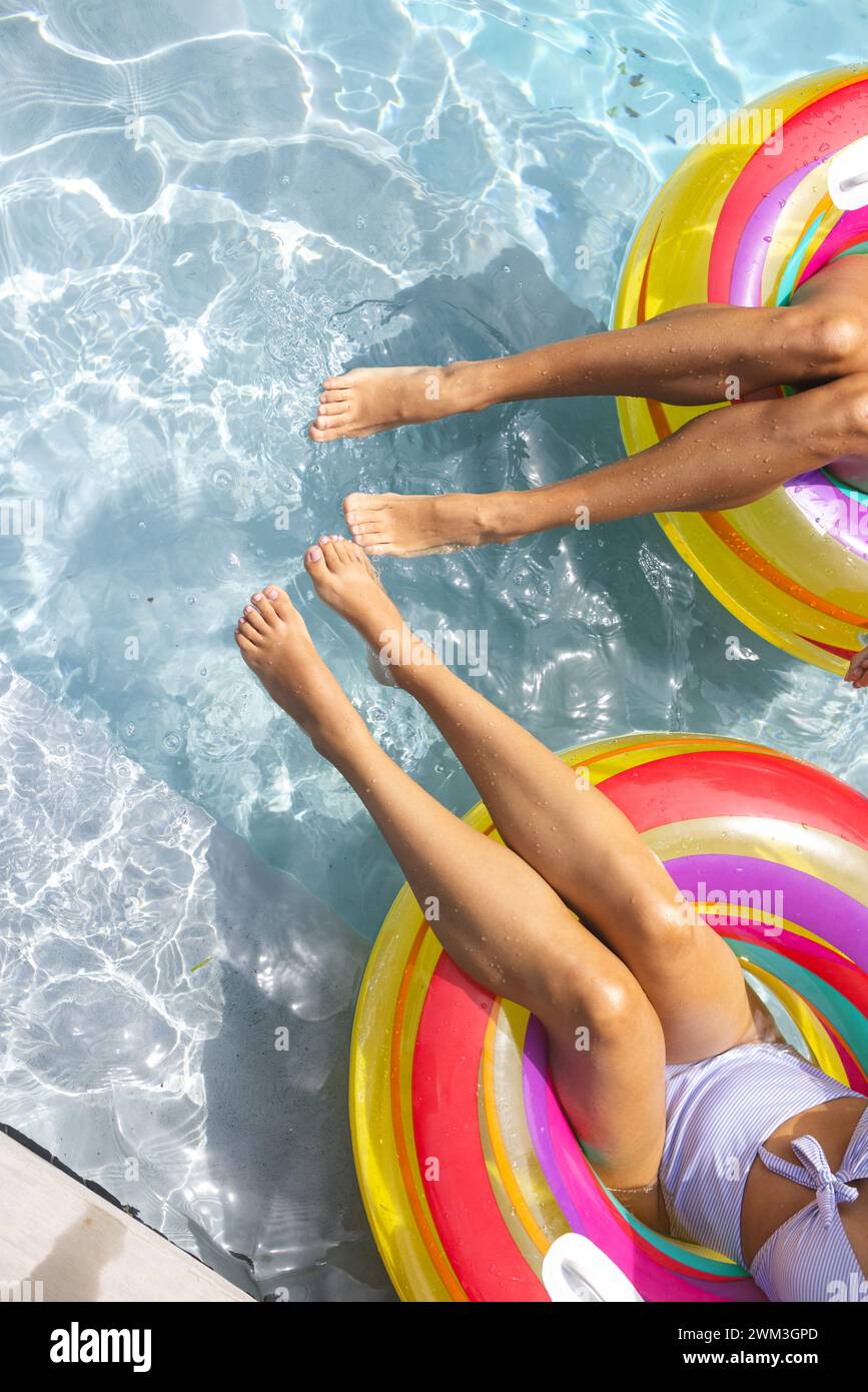 Zwei Personen entspannen sich auf farbenfrohen Schwimmbecken mit Kopierraum Stockfoto