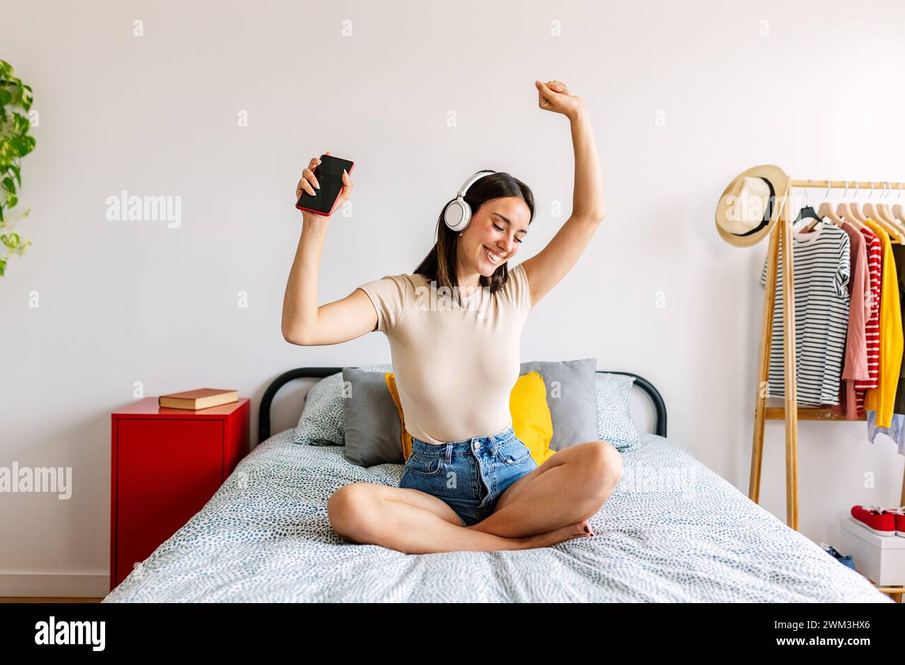Glückliches, hübsches Mädchen, das zu Hause Online-Musik mit Kopfhörern hört Stockfoto