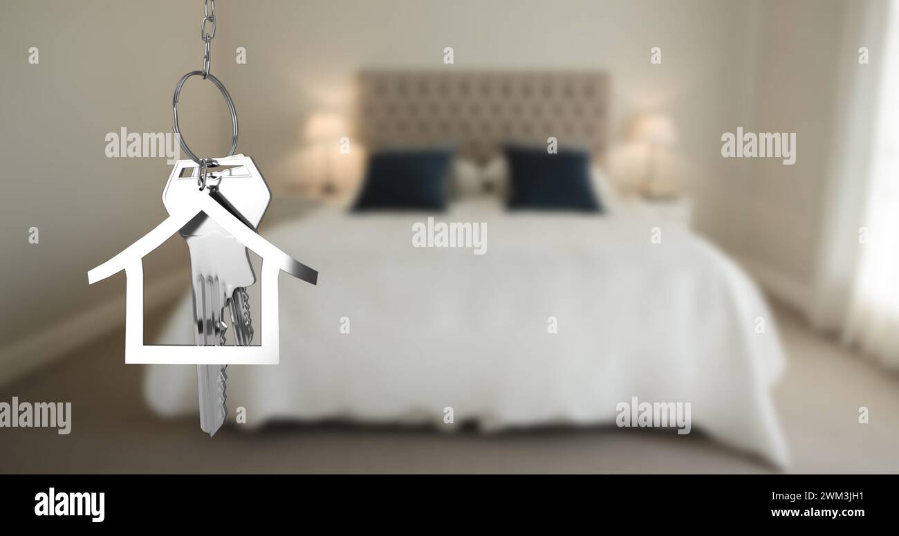 Bild von silbernen Hausschlüsseln und einem hausförmigen Schlüsselanhänger, der über einem unscharf-4K-schlafzimmer hängt Stockfoto