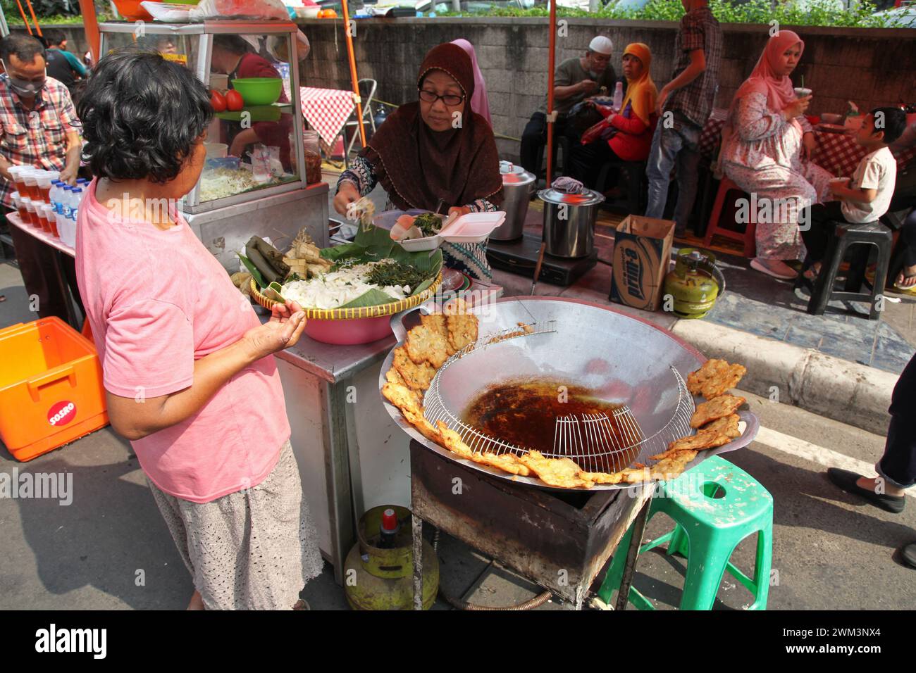 Frau, die am autofreien Tag in der Innenstadt von Jakarta, Indonesien, frisches, frittiertes Backwan oder Bala-Bala-Gemüse verkauft Stockfoto
