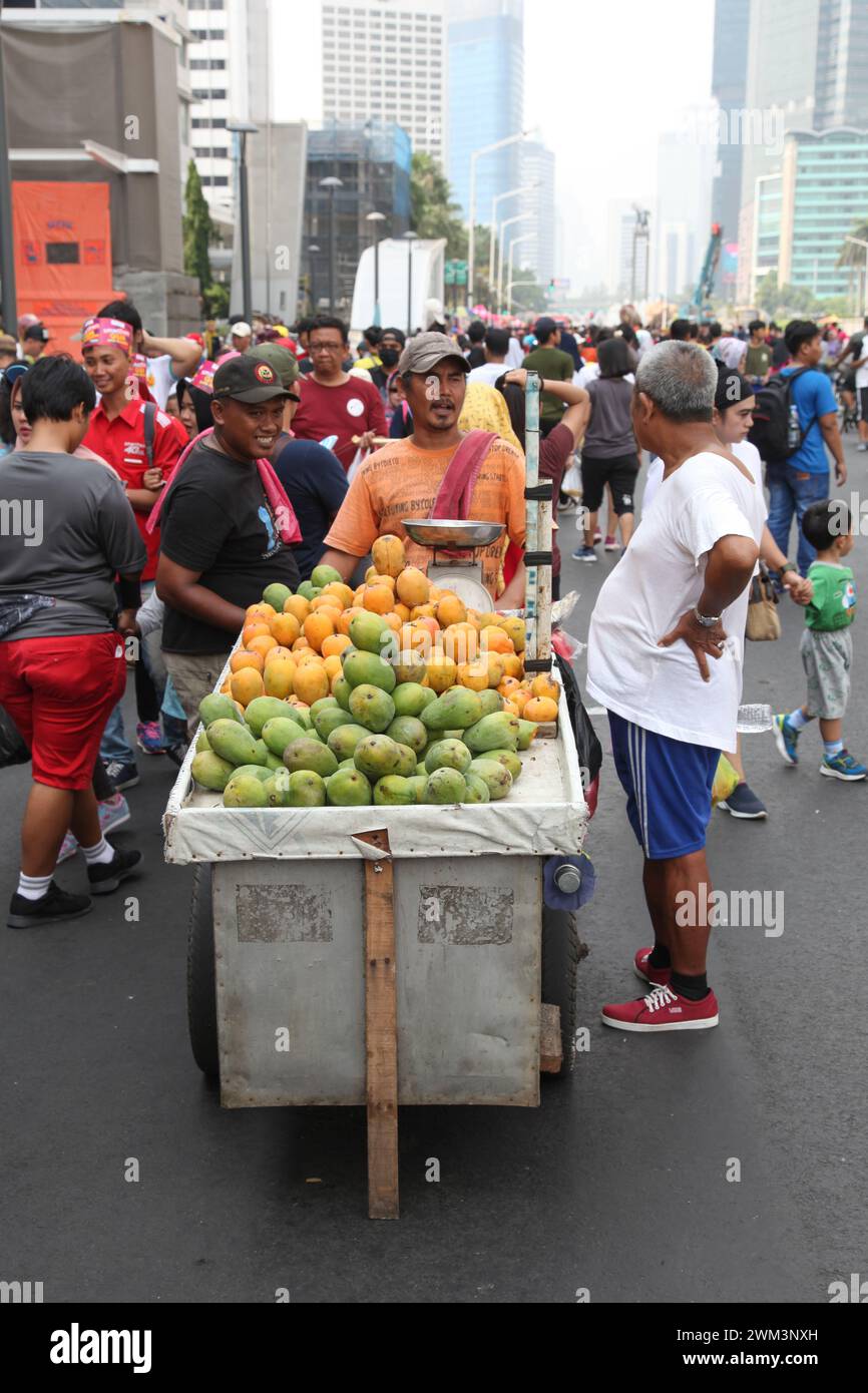 Mann verkauft Mangos auf der Straße am autofreien Tag in Jakarta, Indonesien. Stockfoto