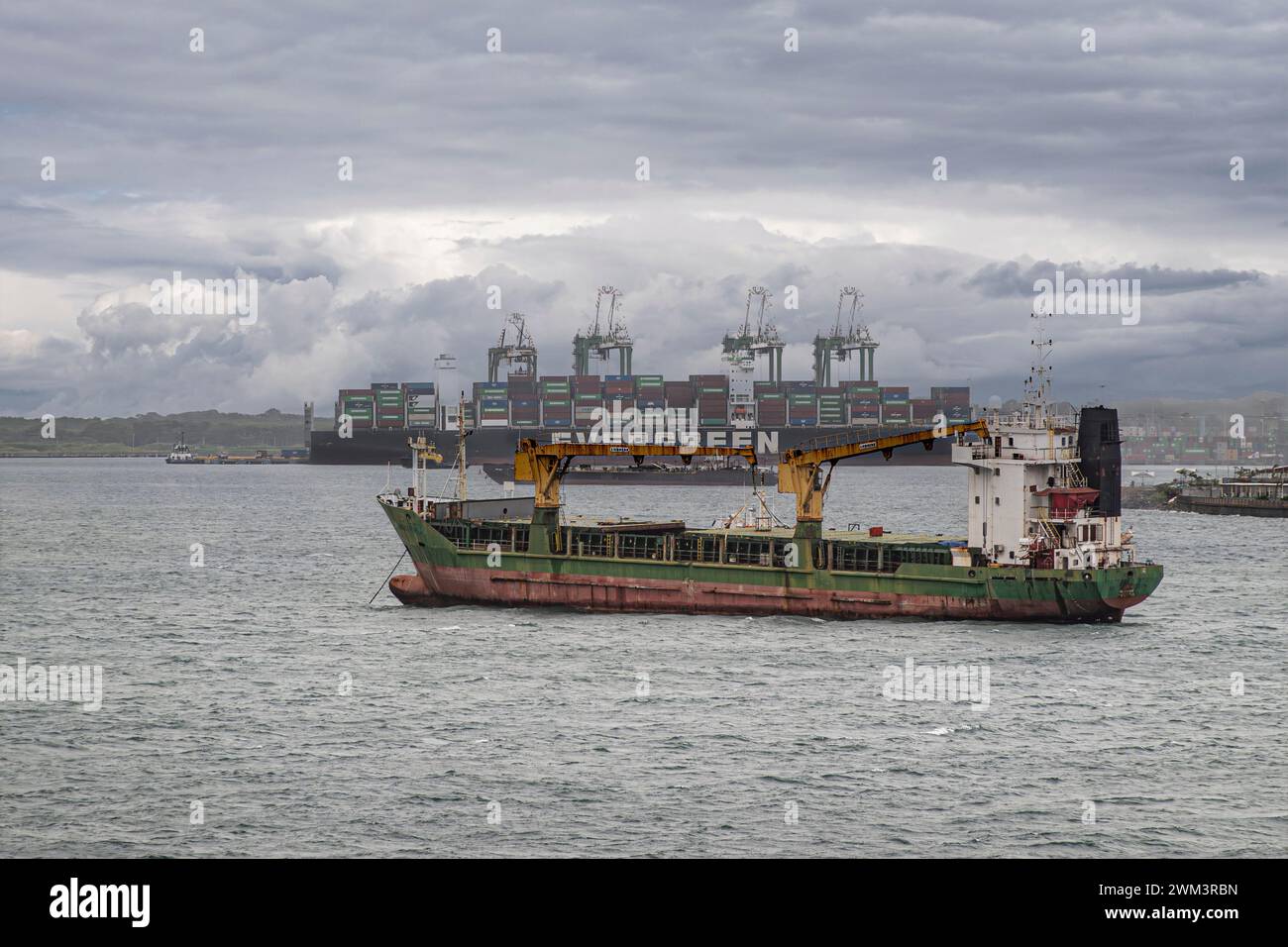 Limon Bay, Colon, Panama - 24. Juli 2023: Evergreen-Containerschiff und leerer Massengutfrachter vor dem Hafen von Colon. Grau c Stockfoto