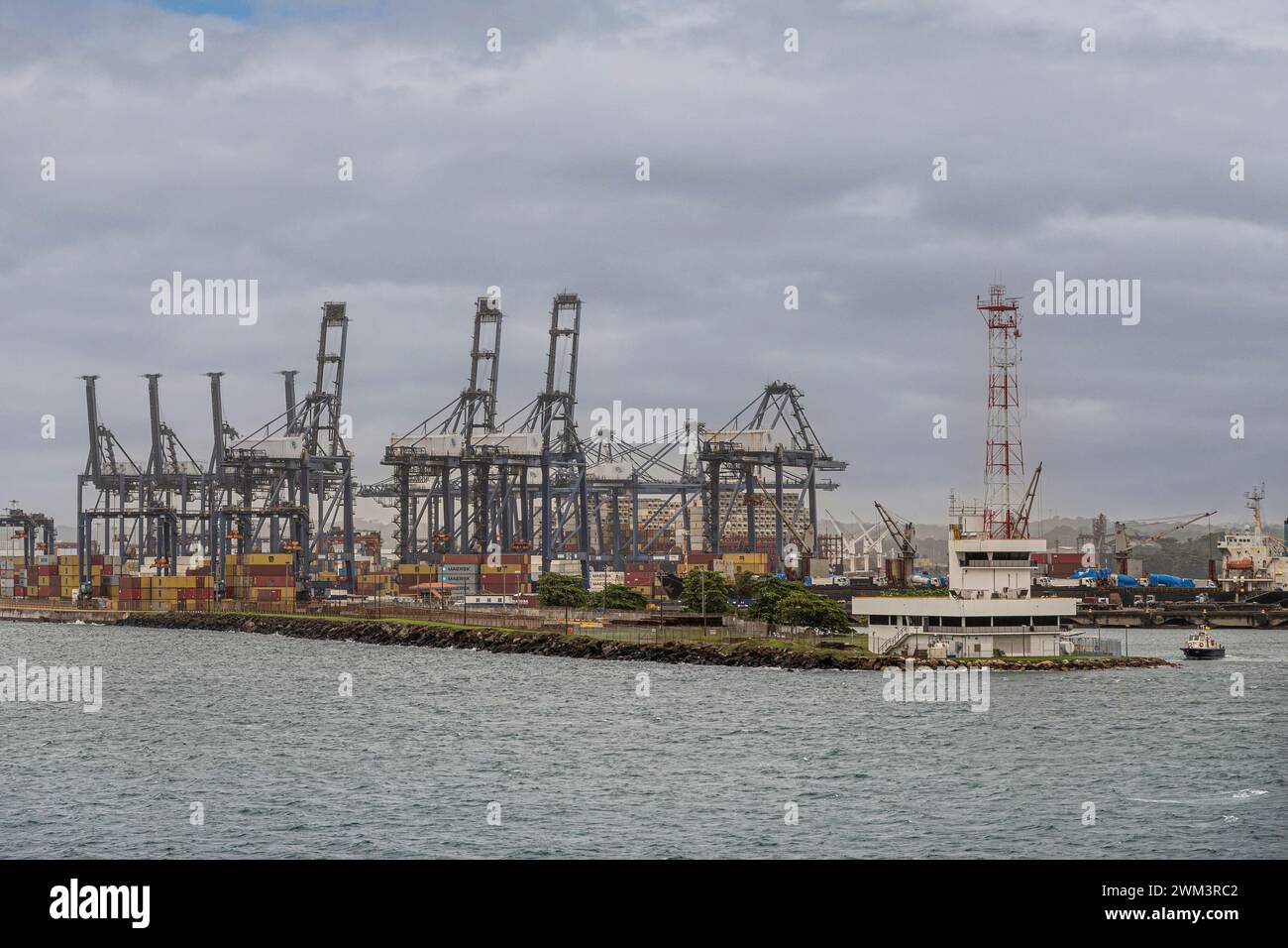 Limon Bay, Colon, Panama - 24. Juli 2023: Hauptquartier des Panama Canal Port mit hohem rot-weißem Antennenturm am Ende des Piers. Puerto de Cristobal (Fortsetzung Stockfoto