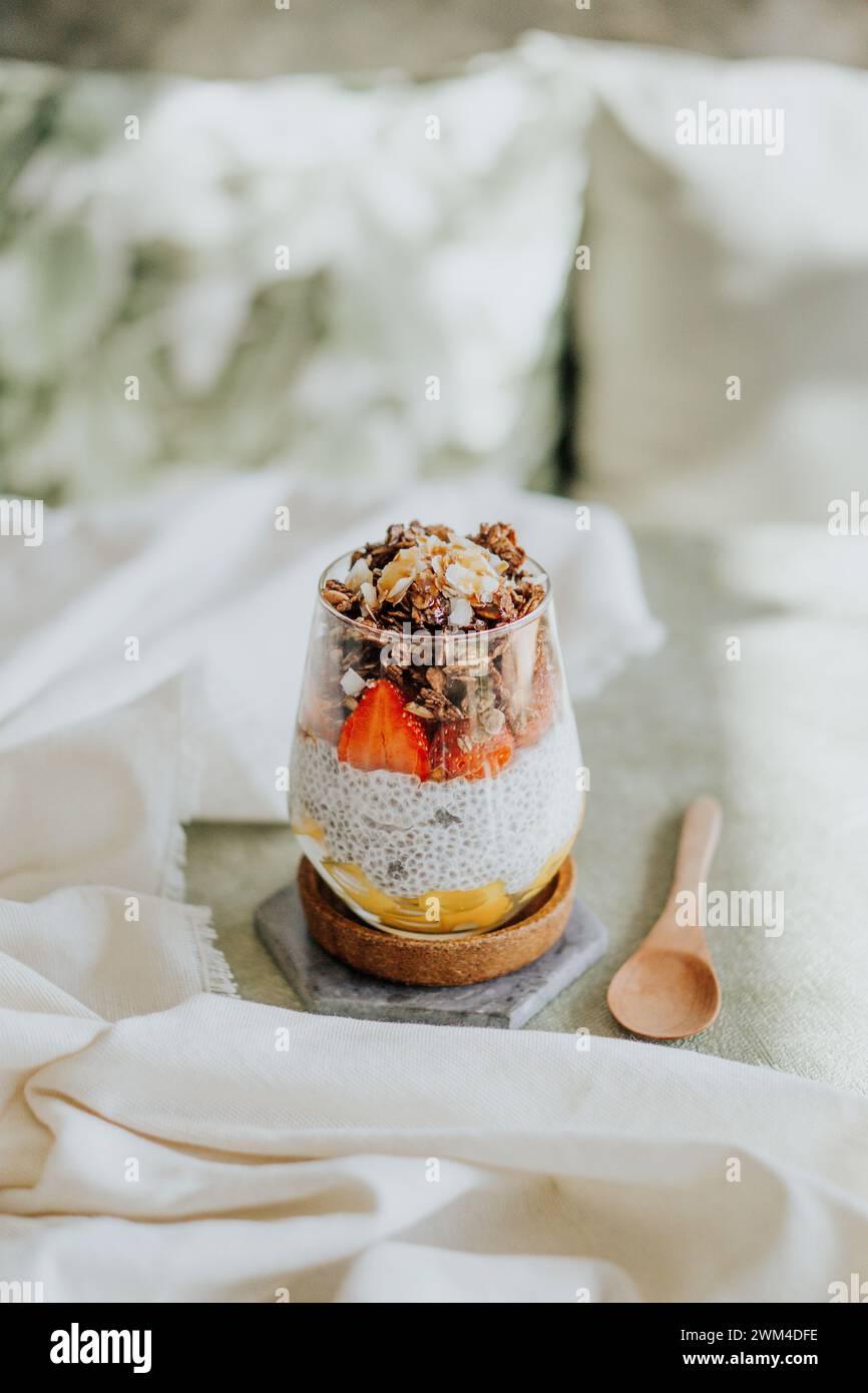 Eine Nahaufnahme eines geschichteten Desserts im Glas mit Pudding mit Erdbeeren und Müsli Stockfoto