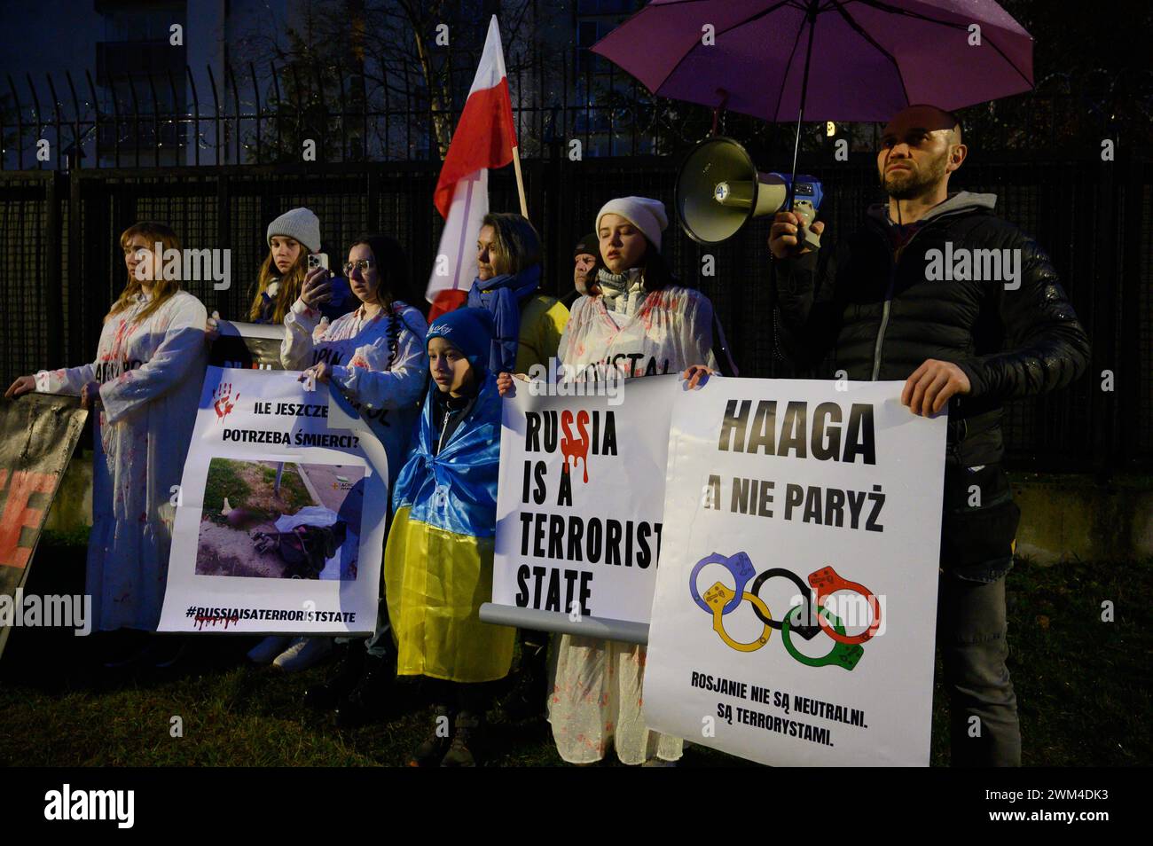 Ukrainer Protestieren Zum Zweiten Jahrestag Der Russischen Invasion. Demonstranten halten Plakate, auf denen steht, dass Russland ein Terrorstaat und der Haag ist, nicht Paris. Die Russen sind nicht neutral, sie sind Terroristen, wenn sie sich am zweiten Jahrestag der umfassenden russischen Invasion der Ukraine in Warschau, Polen, am 24. Februar 2024 versammeln. Ein Dutzend Demonstranten, vor allem ukrainische Bürger, die in Polen leben, veranstalteten früh am Morgen einen Protest, indem sie vor einem Wohngebäude, in dem russische Diplomaten leben, Geräusche von Luftangriffsirenen und Explosionen spielten. Warschau Polen Copyright: XAleksanderxKalkax Stockfoto