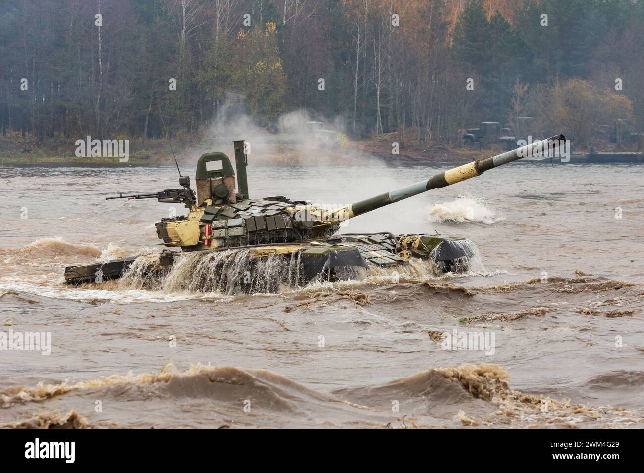Ein mächtiger Tank für schwere Kampffahrzeuge verlässt das Flussufer, nachdem er eine Wasserbarriere entlang des Bodens gedrückt hat Stockfoto