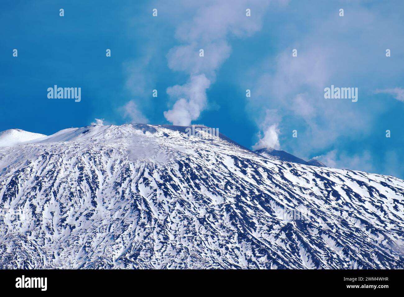 Der mit Schnee bedeckte Vulkan Ätna gibt Dampf aus Gipfelkratern im Ätna-Park in Sizilien, Italien ab Stockfoto