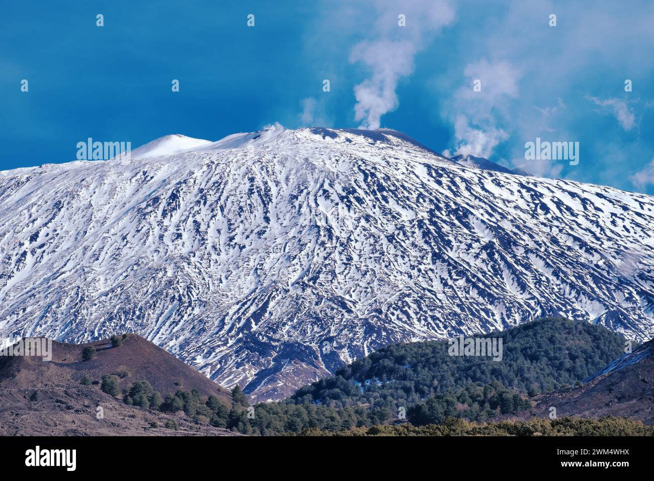 Der mit Schnee bedeckte Vulkan Ätna gibt Dampf aus Gipfelkratern im Ätna-Park in Sizilien, Italien ab Stockfoto