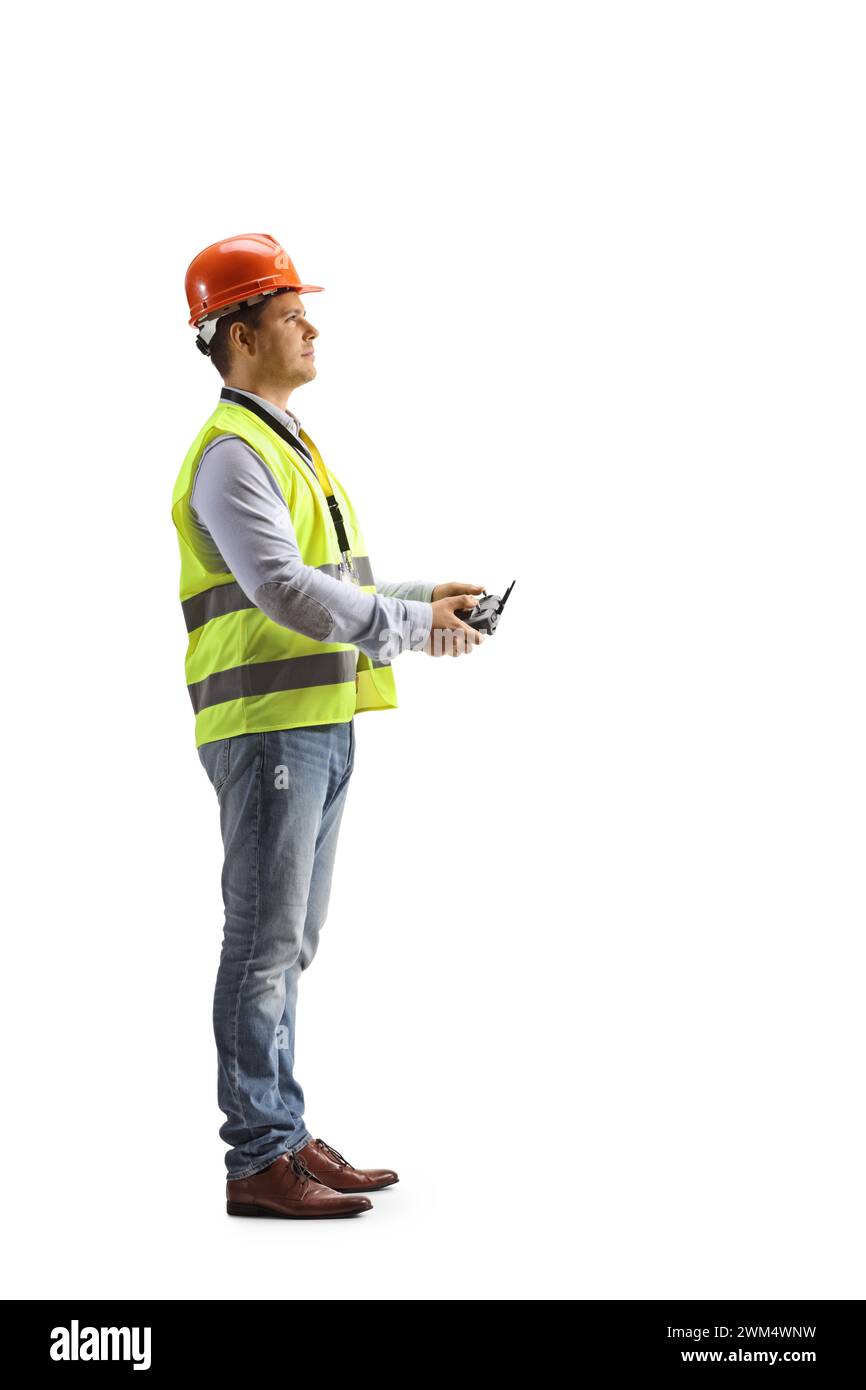 Ingenieur in einer Sicherheitsweste, der eine Drohnenfernsteuerung isoliert auf weißem Hintergrund hält Stockfoto