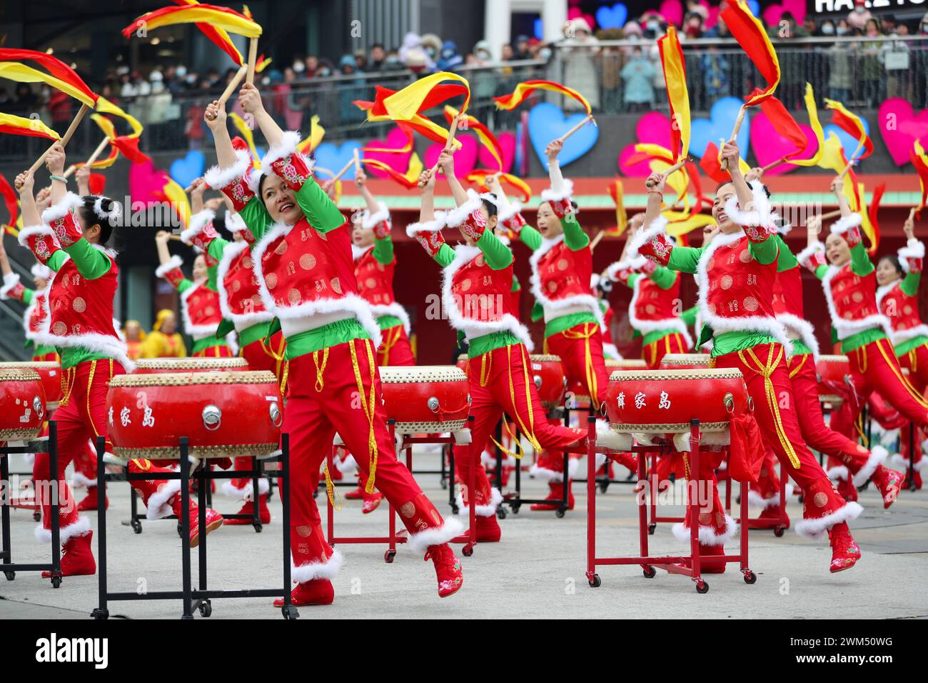 QINGDAO, CHINA - 24. FEBRUAR 2024 - Menschen spielen Gongs und Trommeln beim Qingdao West Coast New Area Marine Carnival in Qingdao, Provinz Shandong. Stockfoto
