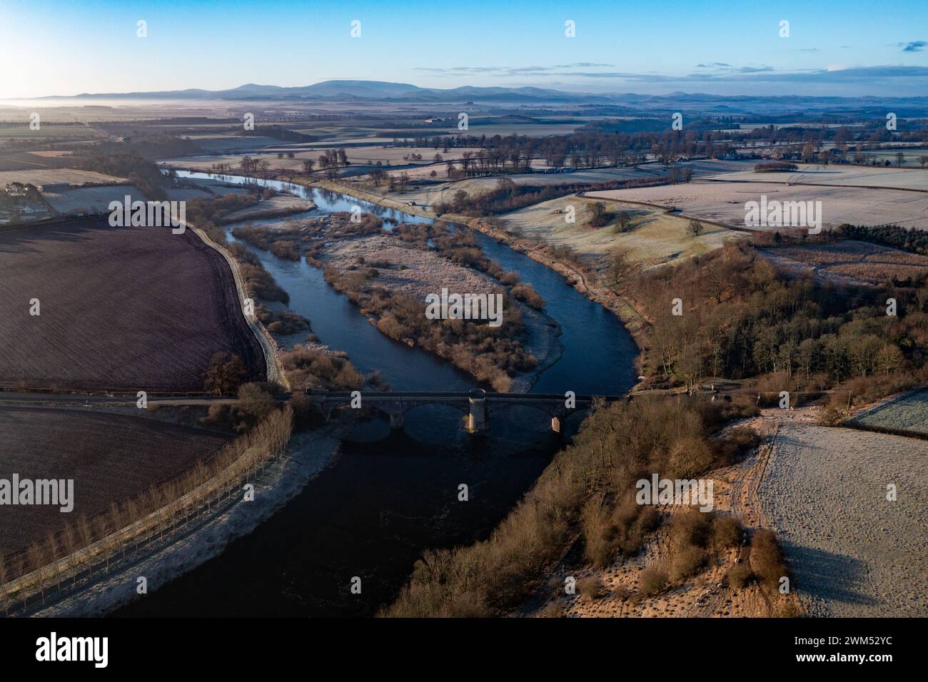 Der Fluss Tweed blickt auf den Fluss über Ladykirk und Norham Bridge mit den Cheviot Hills im Hintergrund Stockfoto