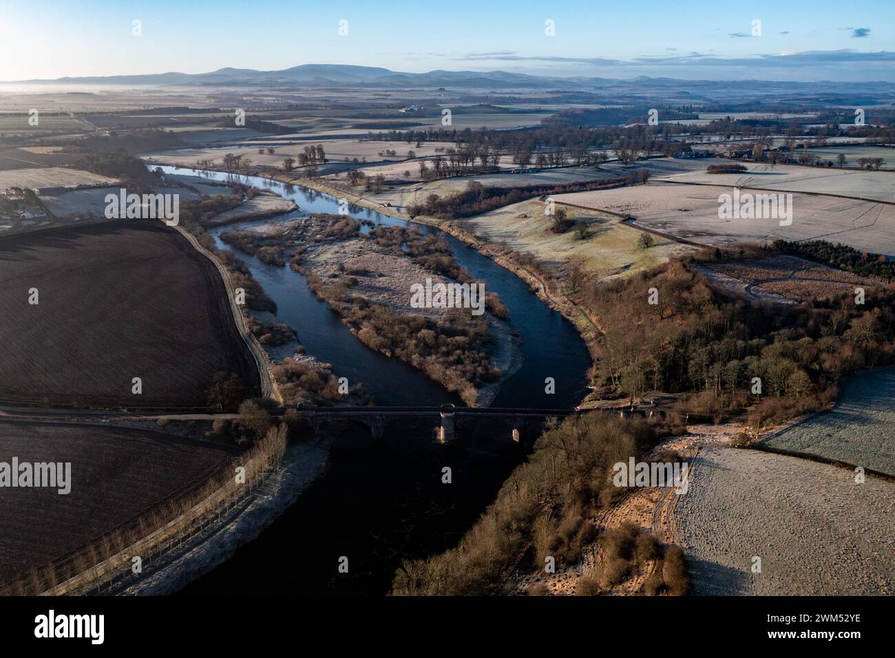 Der Fluss Tweed blickt auf den Fluss über Ladykirk und Norham Bridge mit den Cheviot Hills im Hintergrund Stockfoto