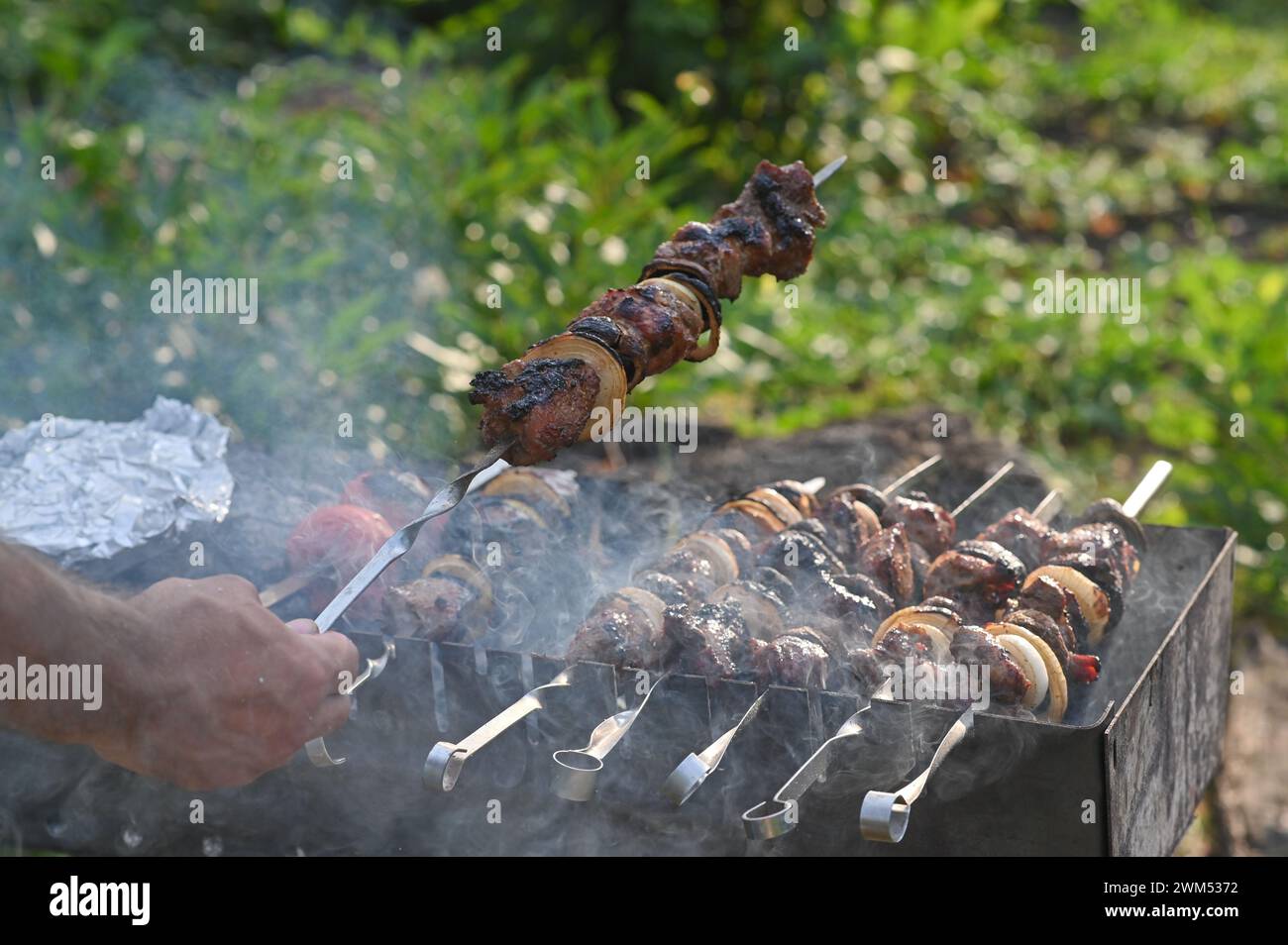 Koche Shish Kebab auf Spießen. Konzept des Street Food. Stockfoto