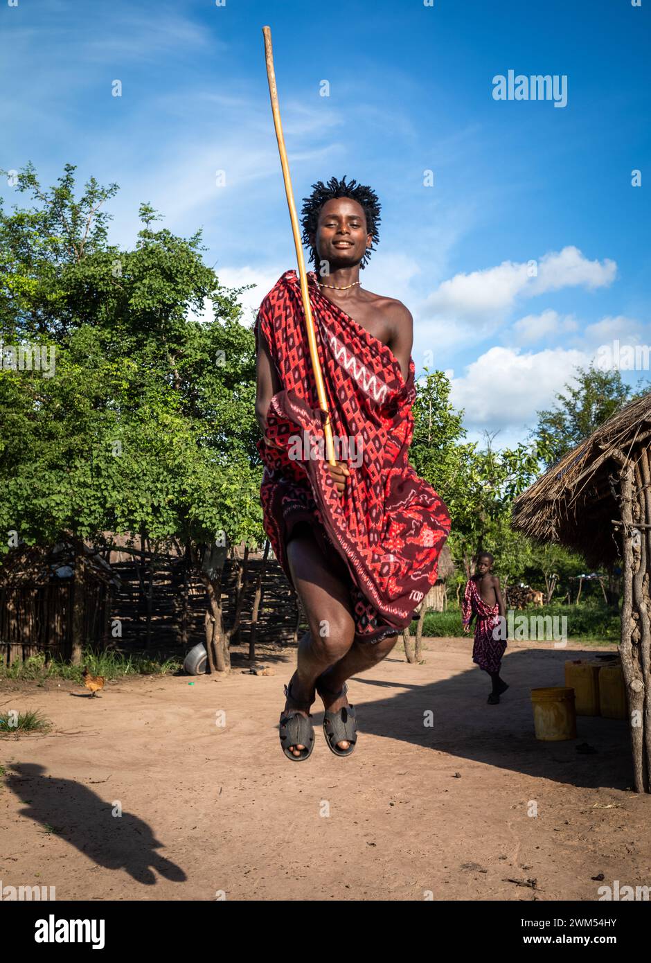 Ein junger Maasai-Krieger führt den traditionellen Springtanz in seinem Dorf in Mikumi, Tansania, auf Stockfoto