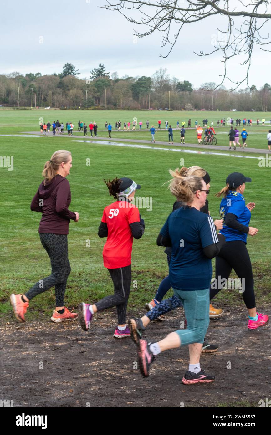 Teilnehmer am Rushmoor Parkrun, einem regulären Samstag-Laufrennen in Aldershot, Hampshire, England, im Februar 2024. Frauen im Sport. Stockfoto