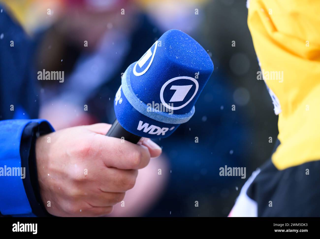 Winterberg, Deutschland. Februar 2024. Bobbahn: Weltmeisterschaften, Monobob, Frauen, 2. Lauf. Ein ARD-Sportreporter hält ein Mikrofon mit dem WDR-Logo. Robert Michael/dpa/Alamy Live News Stockfoto