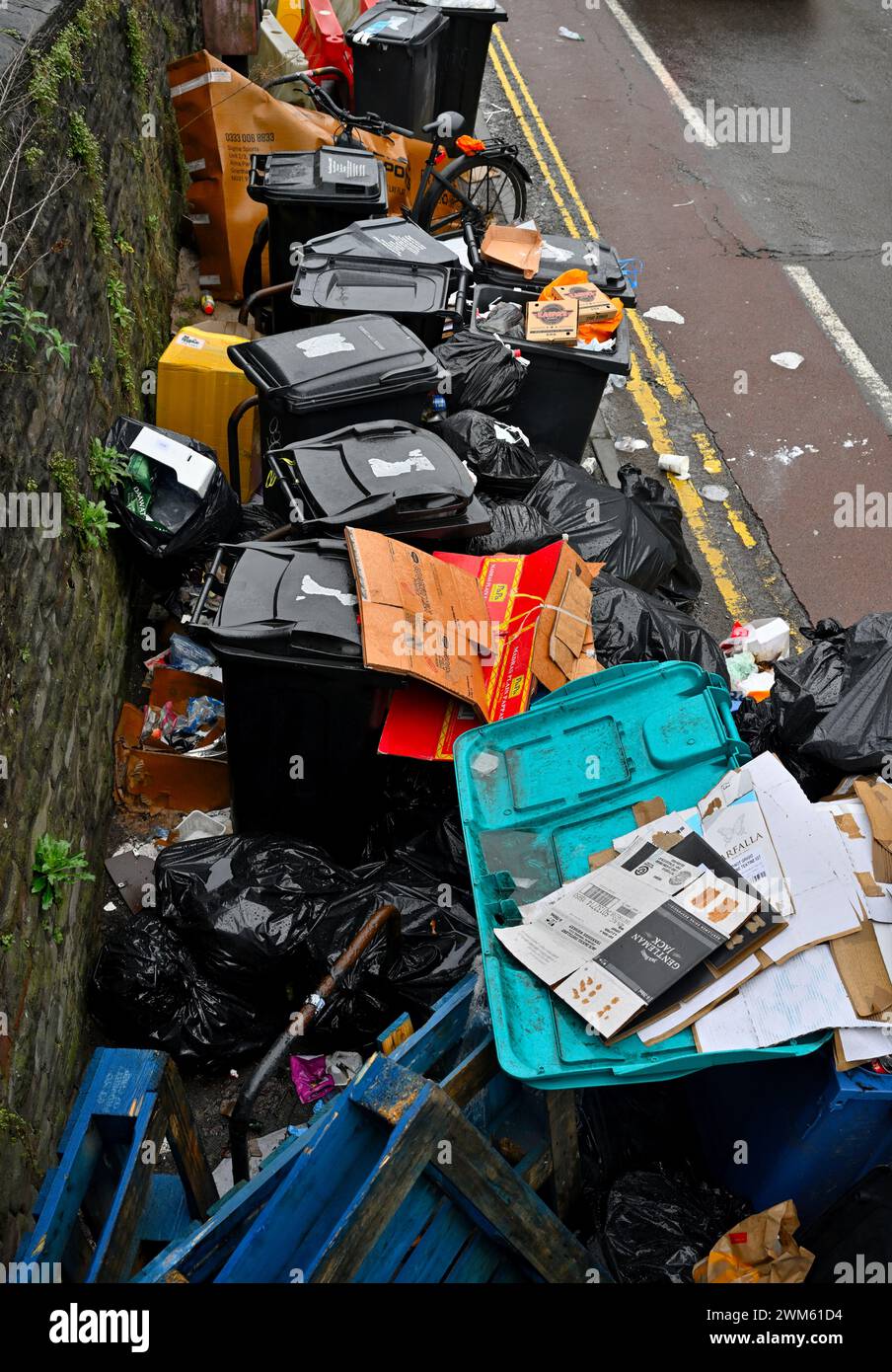 Volle, überfüllte Abfallbehälter und fliegende Abfälle an der Stadtstraße, Bristol, Großbritannien Stockfoto