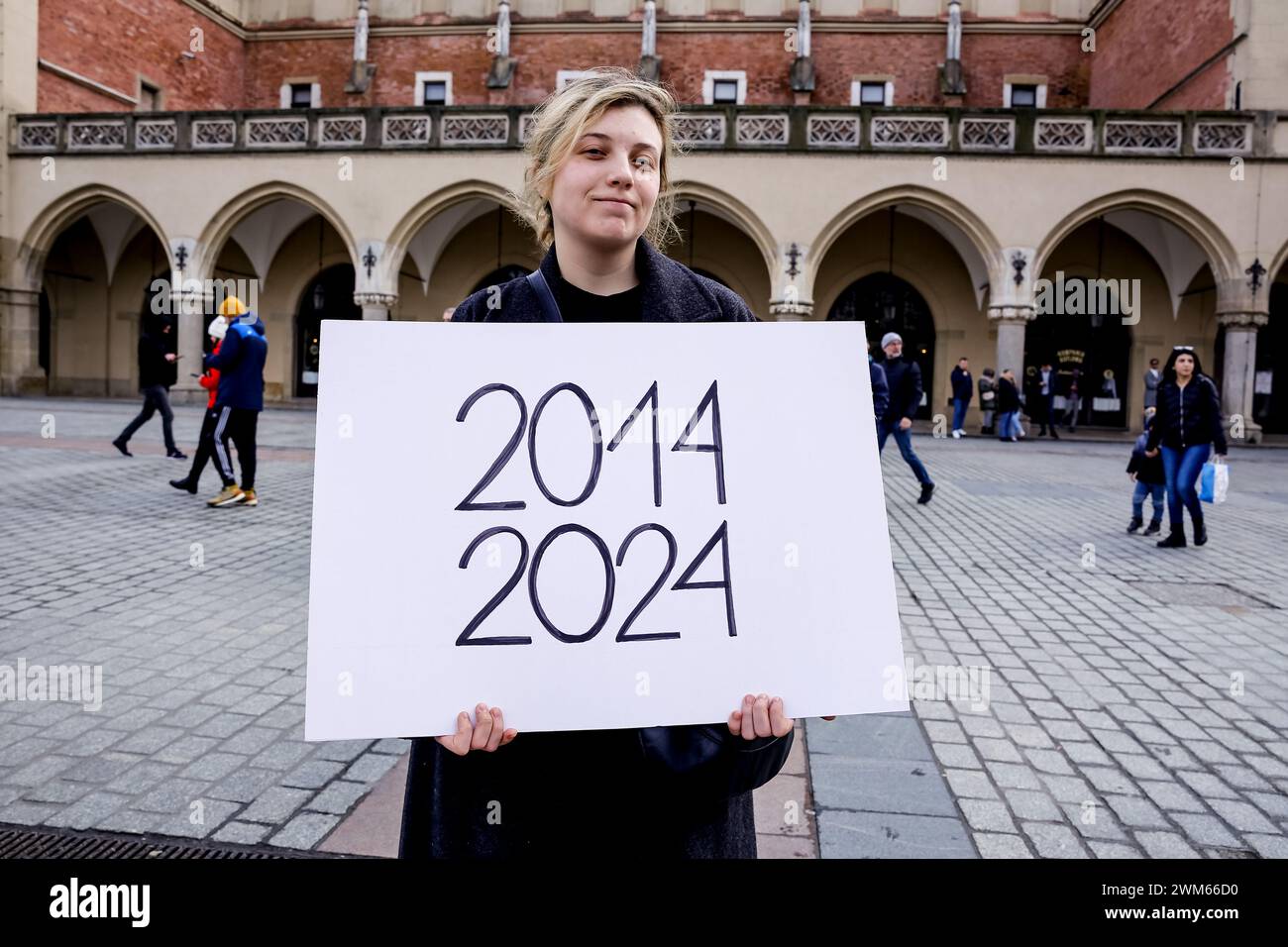 Krakau, Polen, 24. Februar 2024. Eine Frau hält ein Banner mit 2014-2024 Daten, das ein Datum der russischen Aggression gegen die Ukraine anzeigt, als sie an einem marsch der Unterstützung und der gewerkschaft am zweiten Jahrestag der Invasion der russischen Armee auf der Ukraine auf dem Alten Marktplatz in der Altstadt von Krakau teilnimmt. Der marsch zielt darauf ab, die Einheit des ukrainischen polnischen Volkes zu demonstrieren und die Unterstützung der russischen und weißrussischen Opposition gegenüber dem ukrainischen Kampf zu zeigen. Quelle: Dominika Zarzycka/Alamy Live News Stockfoto