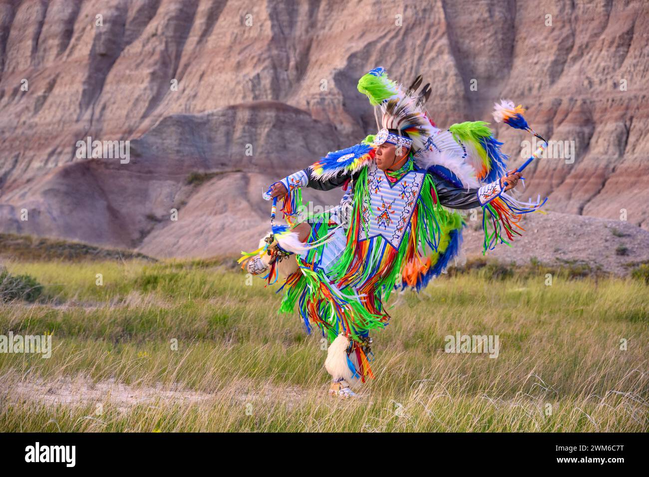 Gerimiah Holy Bull, aus dem Stamm der Sicangu Lakota Oyate, spielt einen Tanz im Badlands National Park, South Dakota. Stockfoto