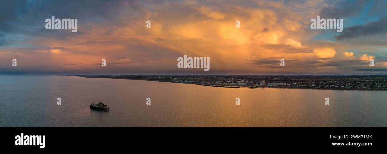 Herne Bay, Kent, Großbritannien. Februar 2024. Ein dramatisches Leuchten bei Sonnenuntergang durch vorbeiziehende Schauern nach einem nassen Nachmittag. Quelle: Jamie McBean/Alamy Live News Stockfoto