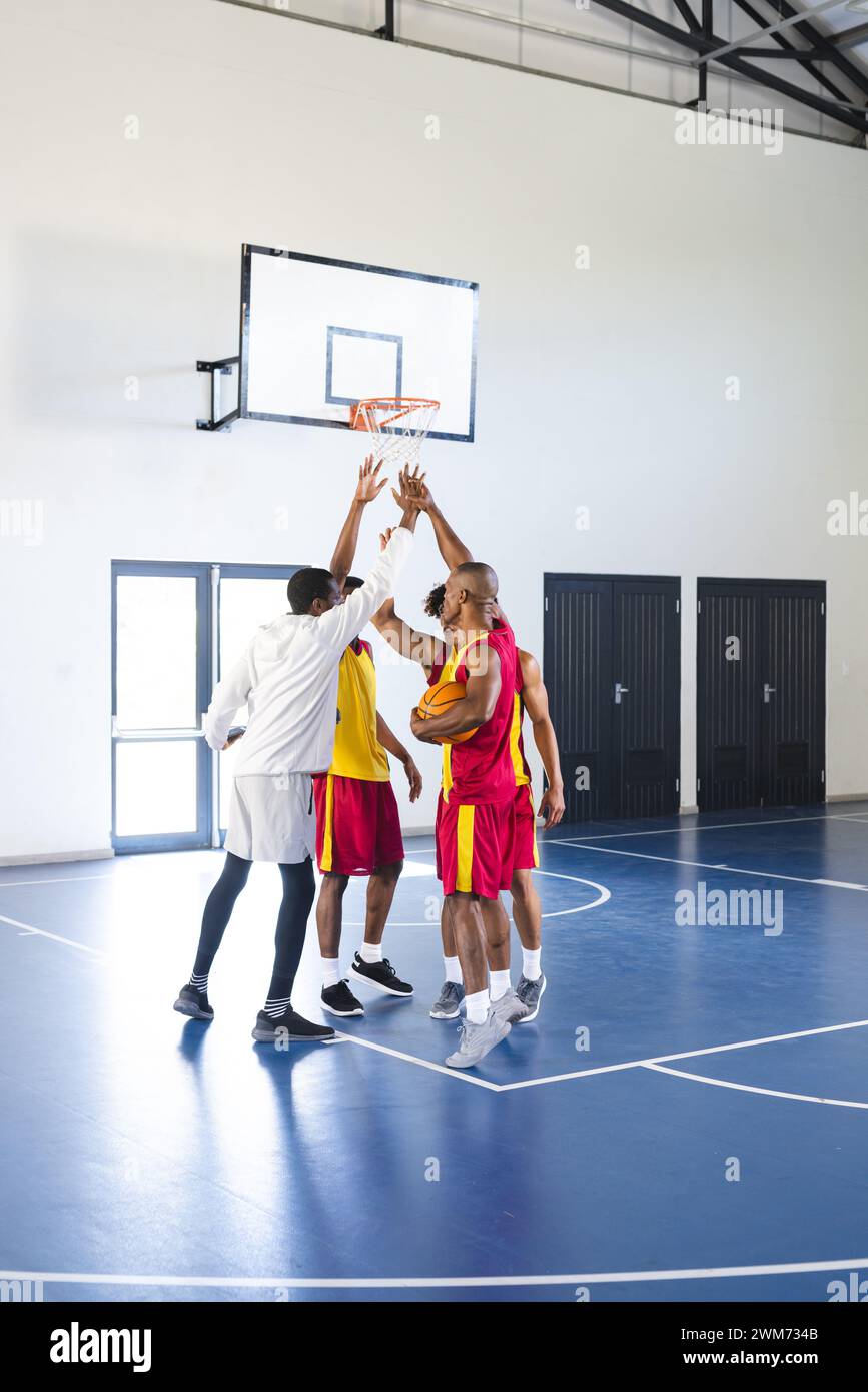 Afroamerikaner und ein junger Mann spielen Basketball drinnen Stockfoto