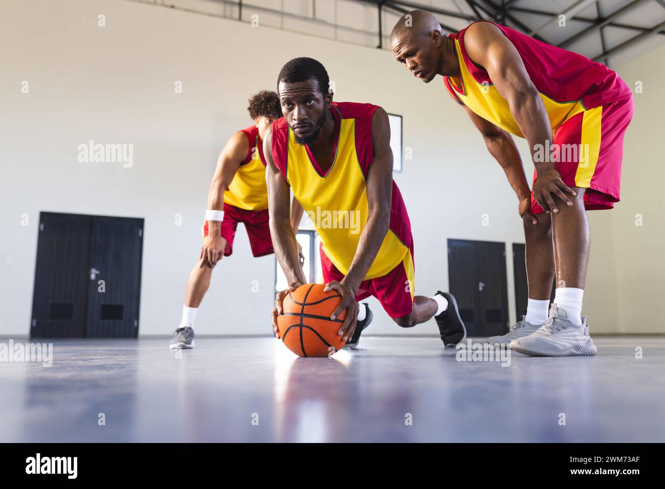 Afroamerikanische Männer spielen Basketball drinnen, mit Kopierraum Stockfoto