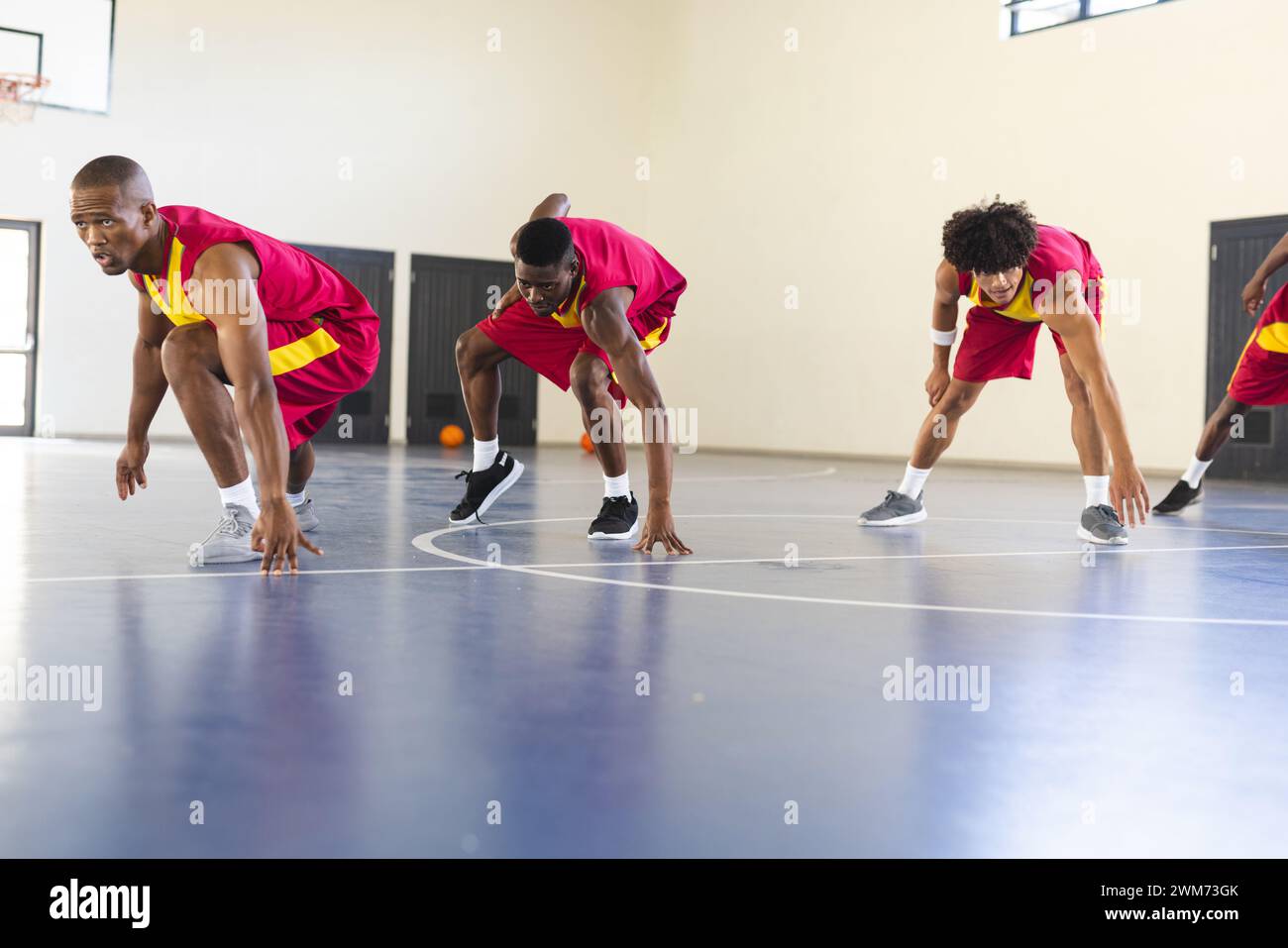Verschiedene Basketballspieler üben auf einem Hallenplatz Stockfoto