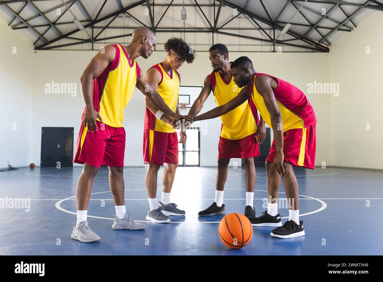 Verschiedene Basketballmannschaften drängen sich auf einem Hallenplatz Stockfoto