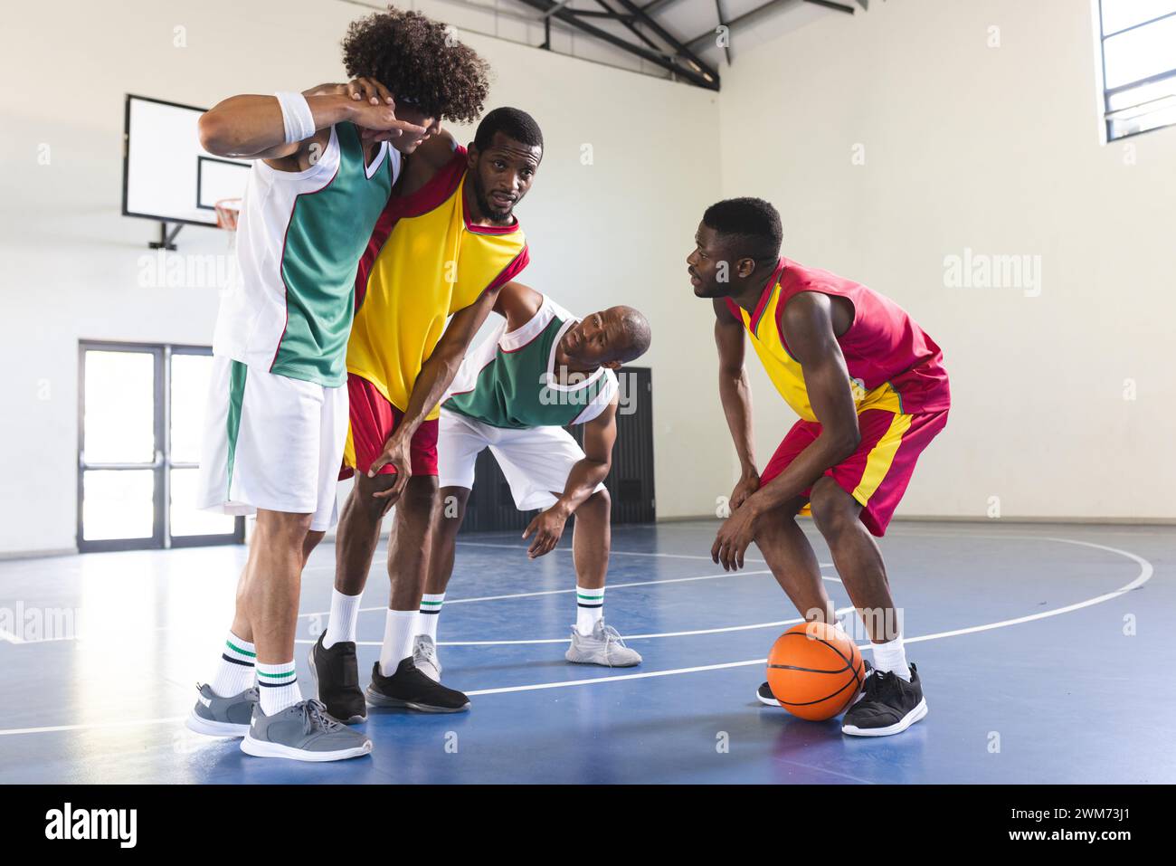 Gruppe afroamerikanischer Männer, die drinnen Basketball spielen Stockfoto