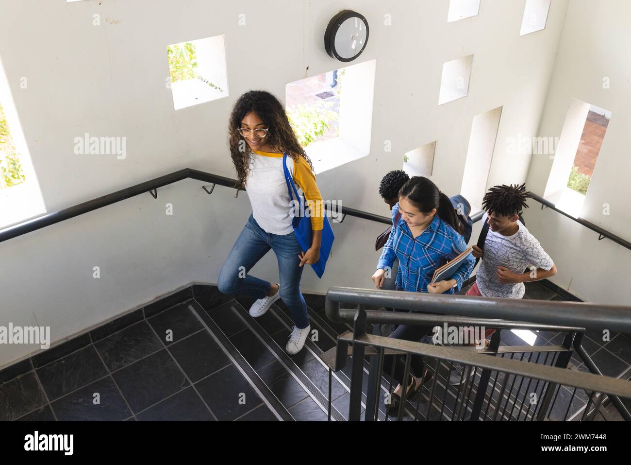 Verschiedene Teenager steigen eine Highschool-Treppe hinab Stockfoto