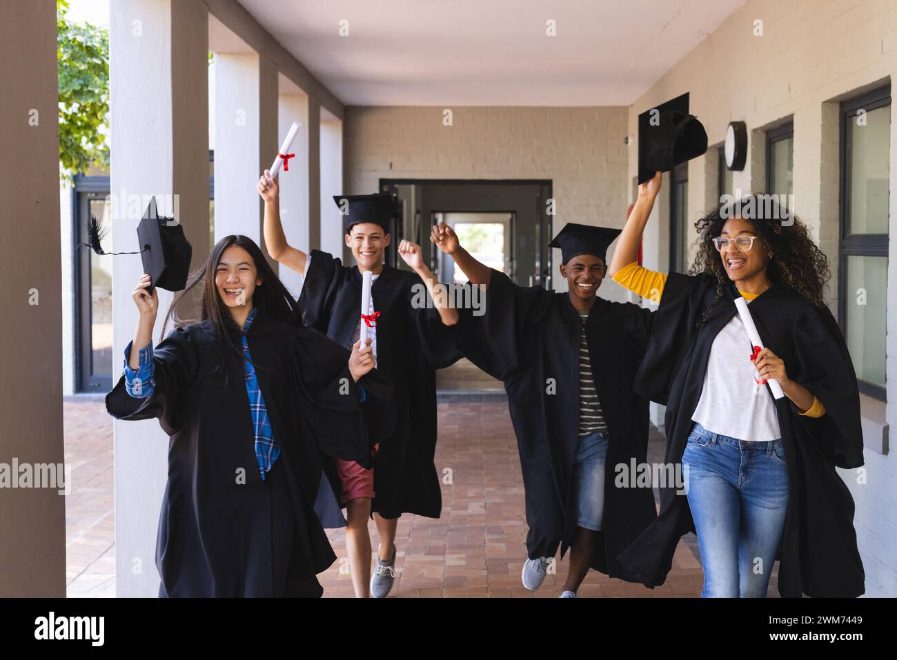 Verschiedene Schüler feiern den Abschluss an der Highschool Stockfoto