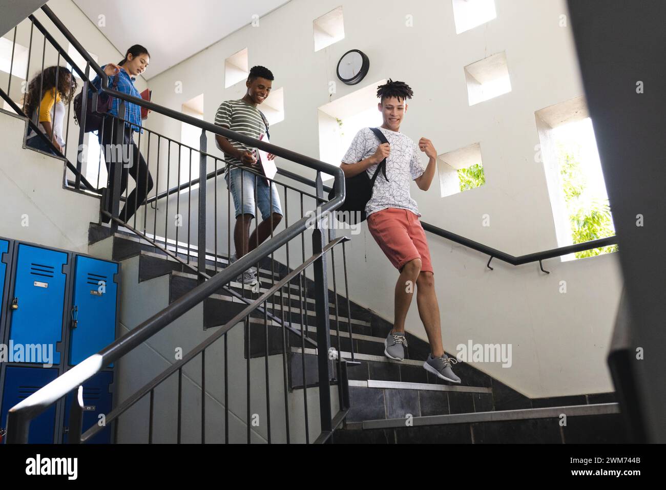 Teenager-Biracial-Jungen und Teenager-Mädchen in einer Highschool-Treppe Stockfoto