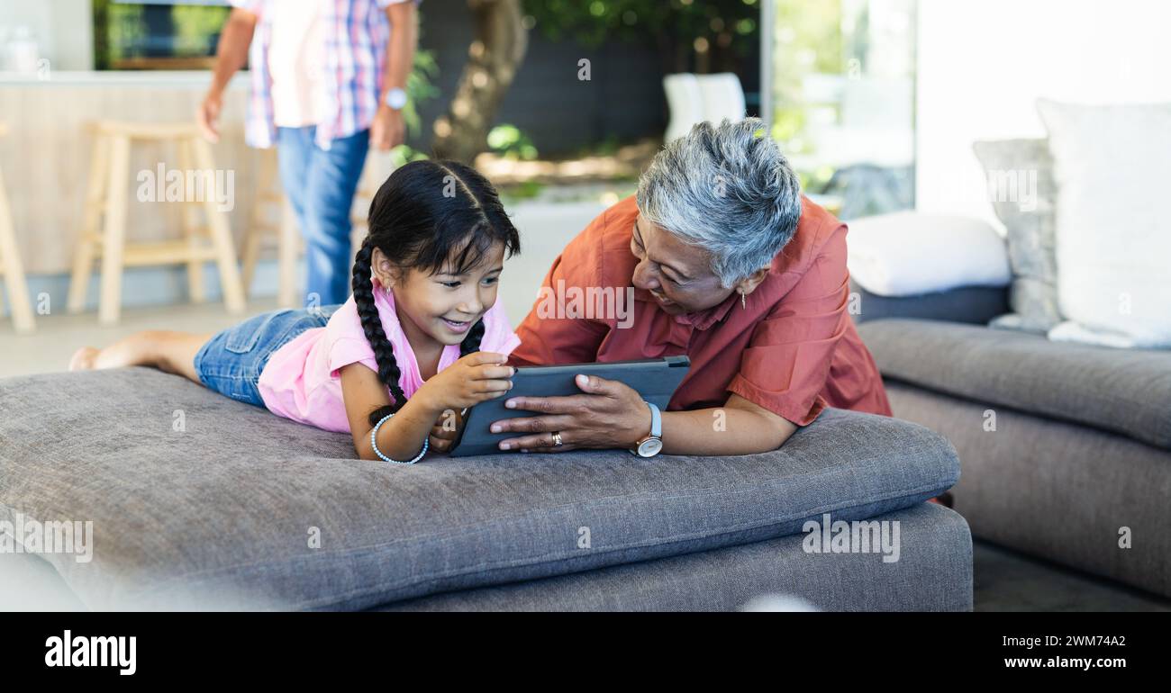Birassische Enkelin und Großmutter teilen sich zu Hause ein Tablet Stockfoto