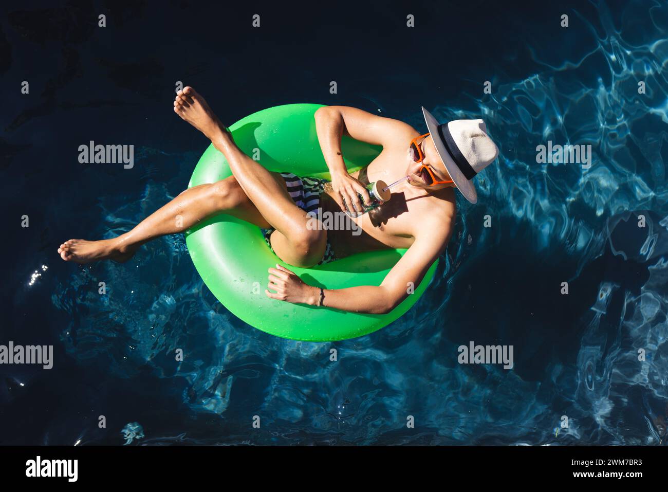 Junger asiatischer Mann entspannt sich auf einem Schwimmbecken, mit Kopierraum Stockfoto