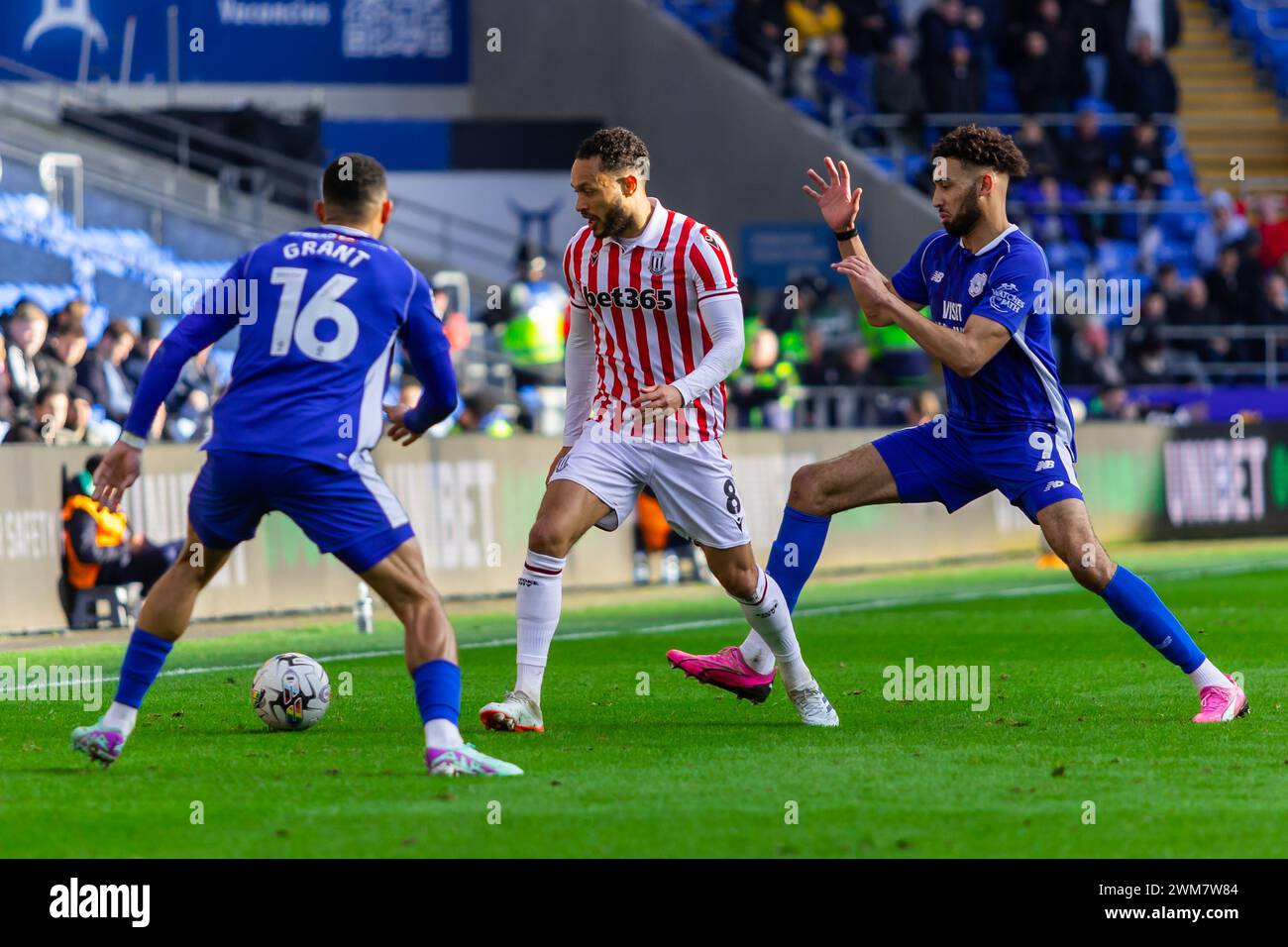 Cardiff, Großbritannien. Februar 2024. Lewis Baker aus Stoke City unter Druck von KION Etete aus Cardiff City (r) und Karlan Grant aus Cardiff City (l) während des EFL Skybet Meisterschaftsspiels Cardiff City gegen Stoke City im Cardiff City Stadium am Samstag, den 24. Februar 2024. Dieses Bild darf nur für redaktionelle Zwecke verwendet werden. Nur redaktionelle Verwendung, Bild nach Credit: Andrew Orchard Sportfotografie/Alamy Live News Stockfoto