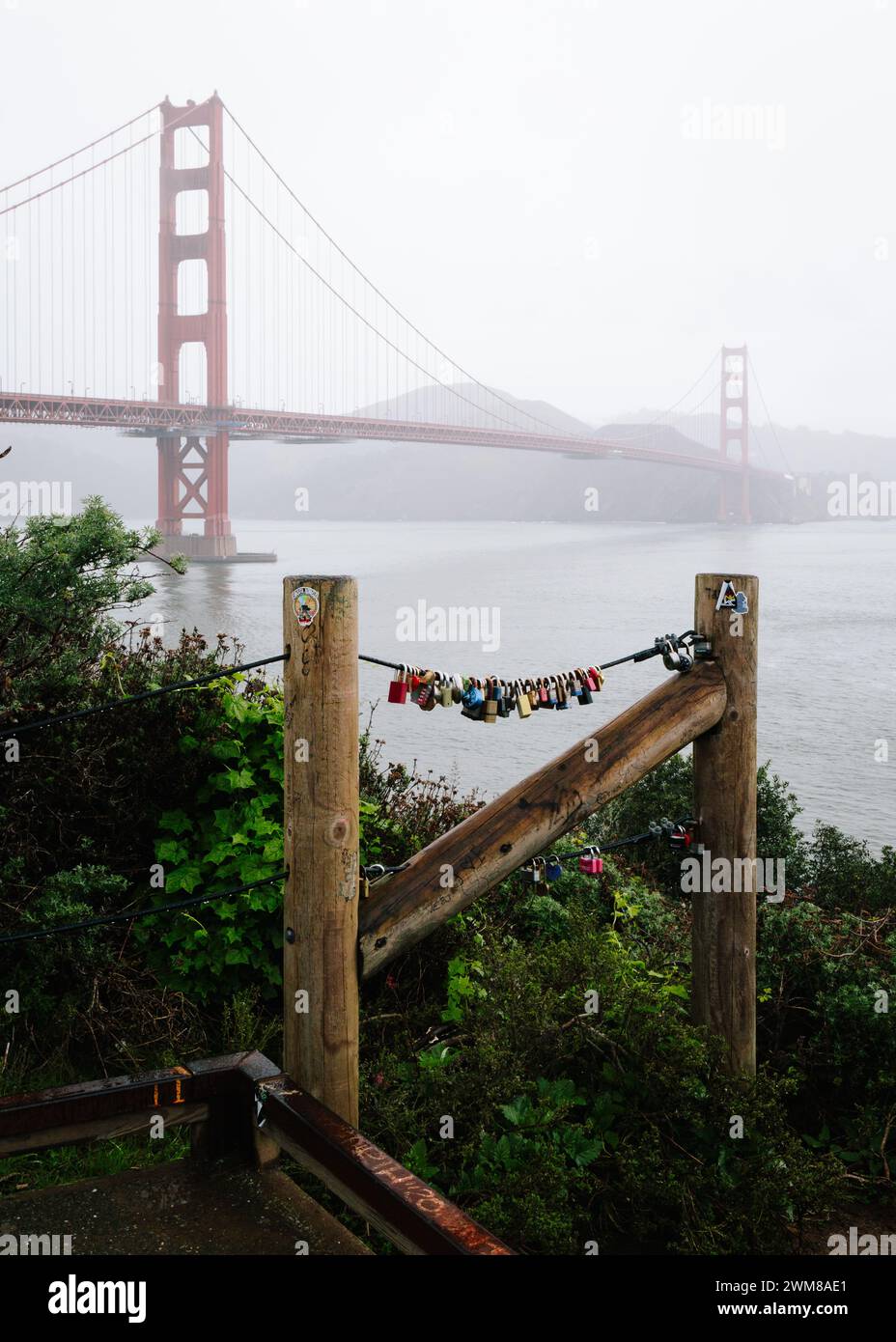 Love schließt sich im Vordergrund mit Golden Gate Bridge in der Ferne, umgeben von Nebel Stockfoto