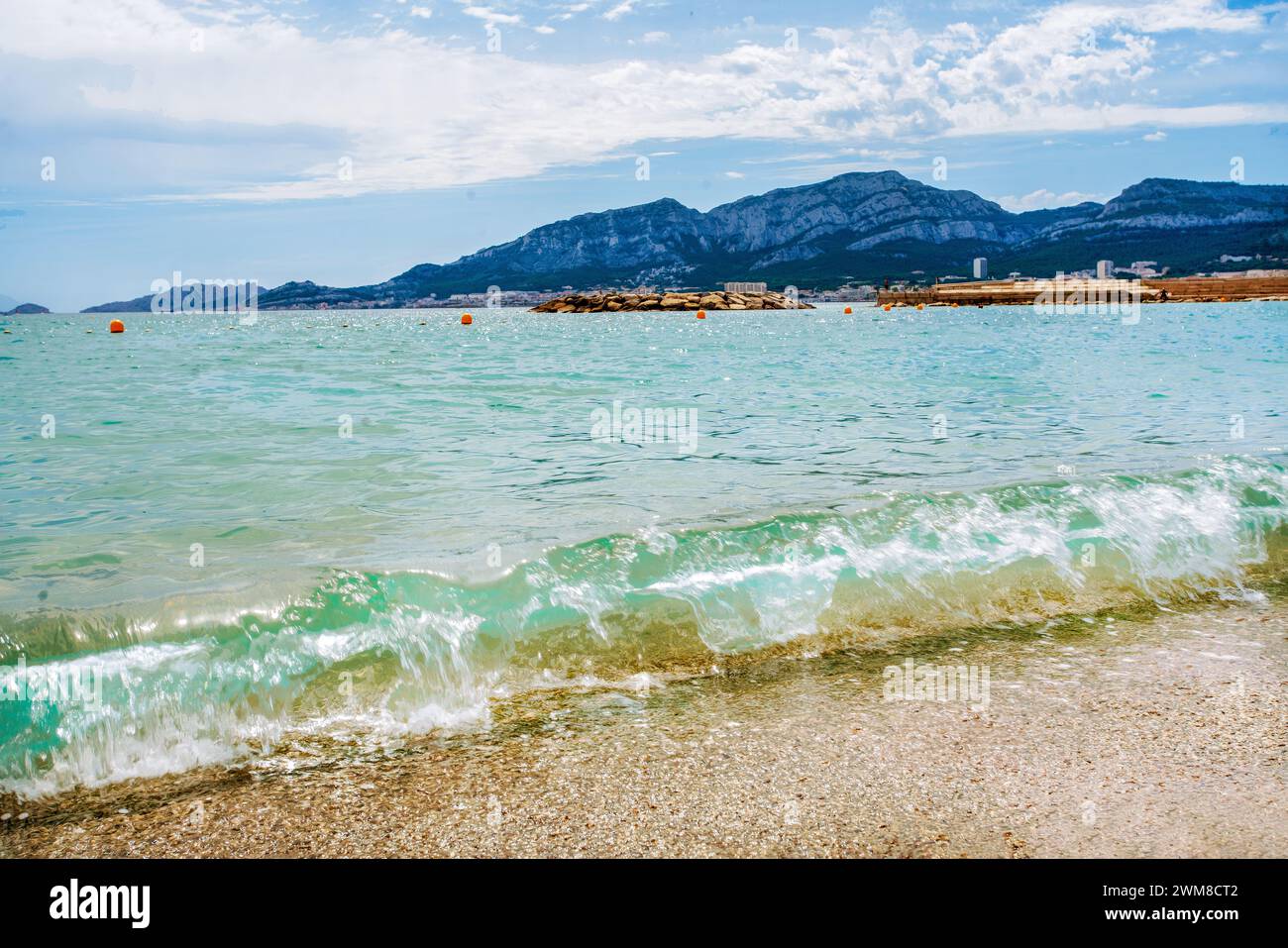 Fantastischer Sommer - milde azurblaue Wellen rollt am Strand mit kleinen Kieselsteinen. Erstaunliche Kreation während des Urlaubs und der Reise in Südeuropa Stockfoto