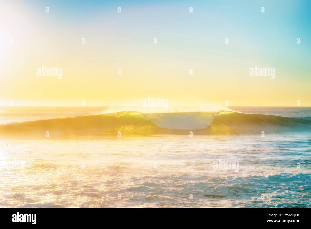 Wunderschöne, hintergrundbeleuchtete Welle, die an einem sonnigen Tag bricht Stockfoto