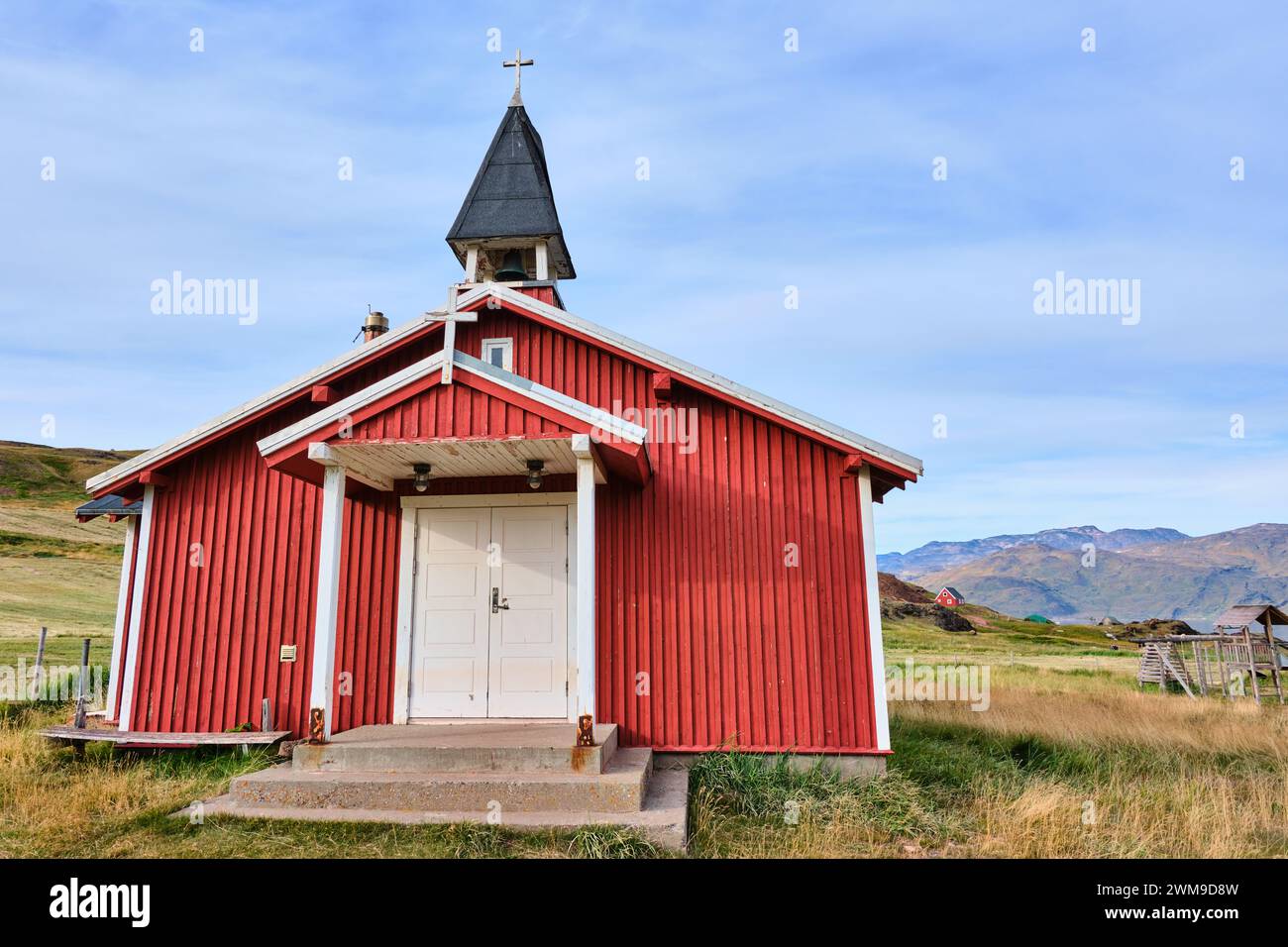 Rote Kirche Qassiarssuk, Grönland. In der Ferne befindet sich die ursprüngliche Kirche in Brattahlíð, Grönlands erster nordischer Siedlung Stockfoto