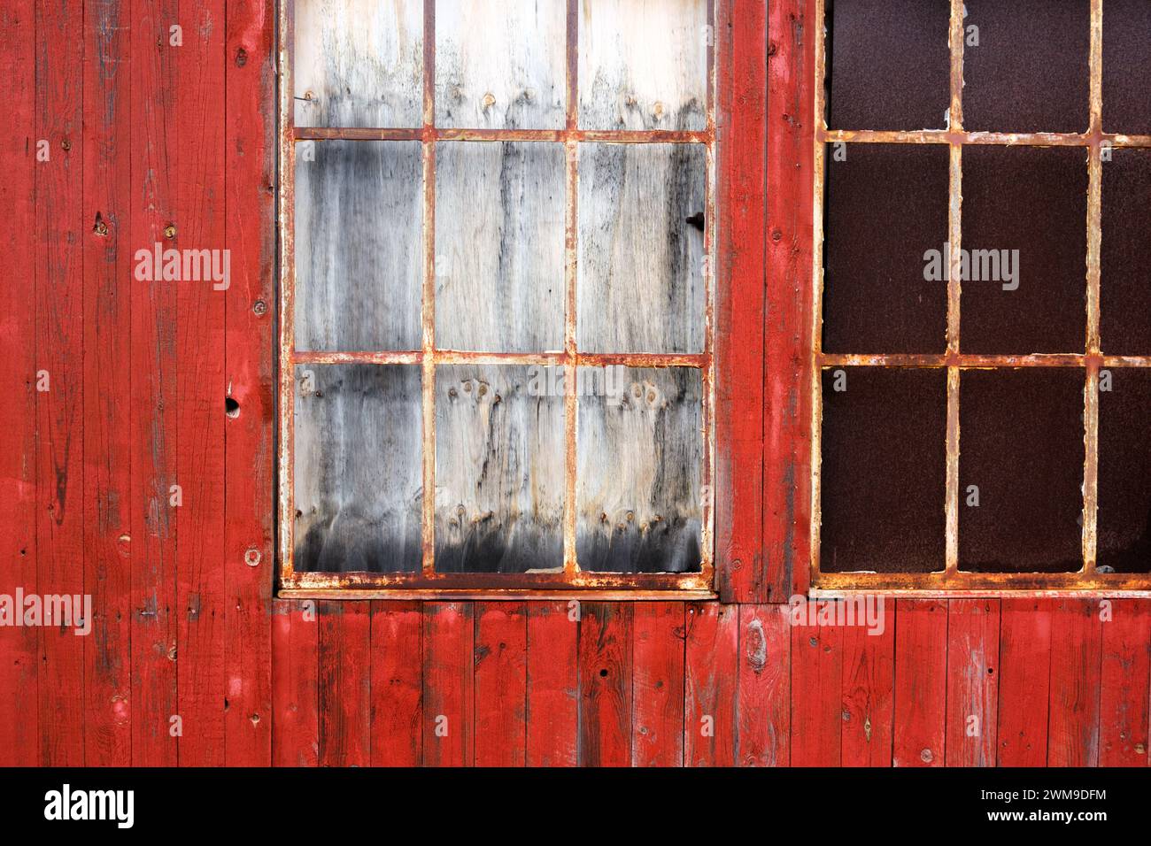 Nahaufnahme eines verrosteten Fensters in einem Gebäude aus roten Holzdielen. Sisimiut, Grönland Stockfoto