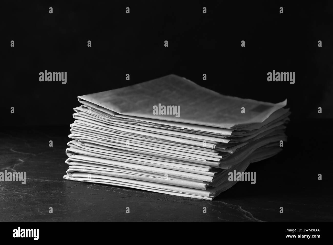 Zeitungsstapel auf einem Tisch aus dunklem Stein. Journalistenarbeit Stockfoto