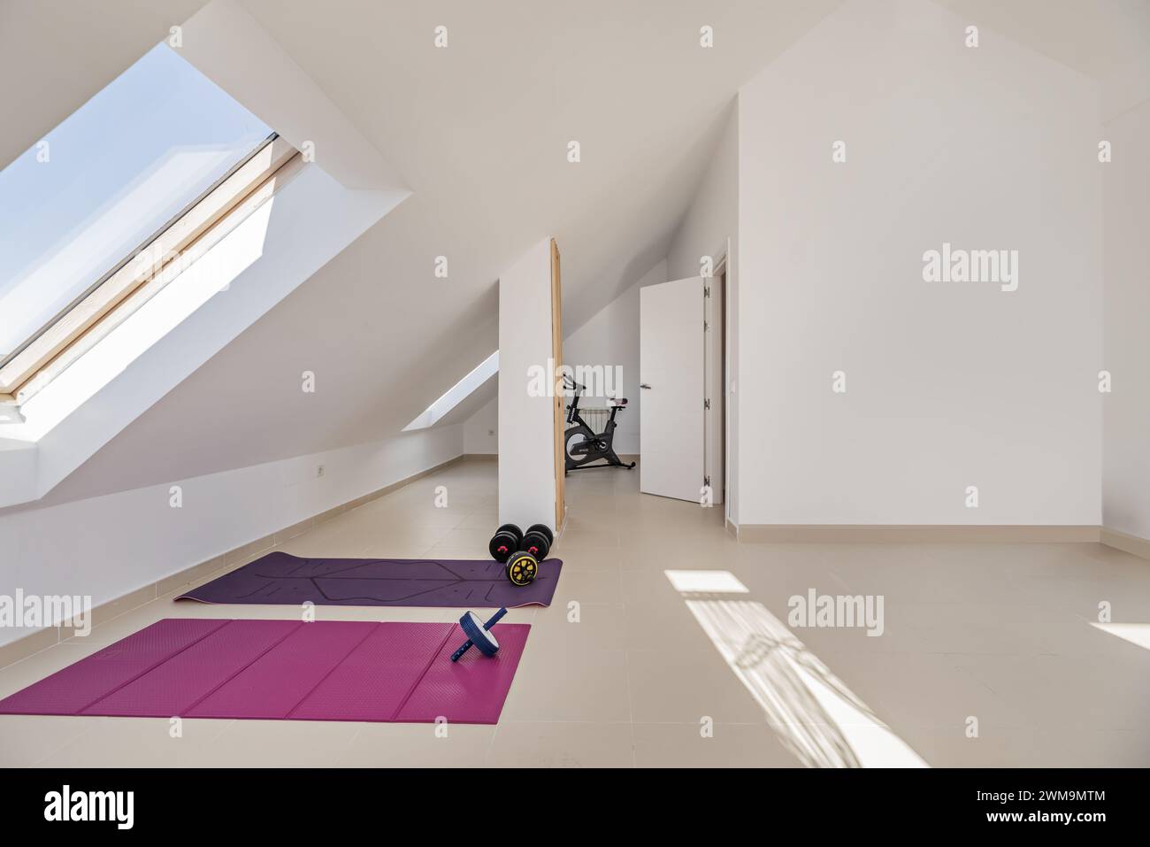Ein Dachgeschoss eines Wohnhauses mit einem Fitnessraum im oberen Stockwerk mit Oberlichtern Stockfoto