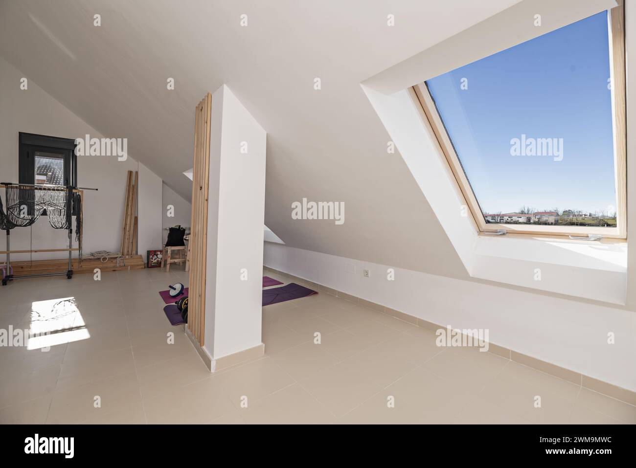 Großes Zimmer mit einem Fitnessraum im oberen Stockwerk mit Dachböden mit Oberlichtern und wunderschöner Aussicht Stockfoto
