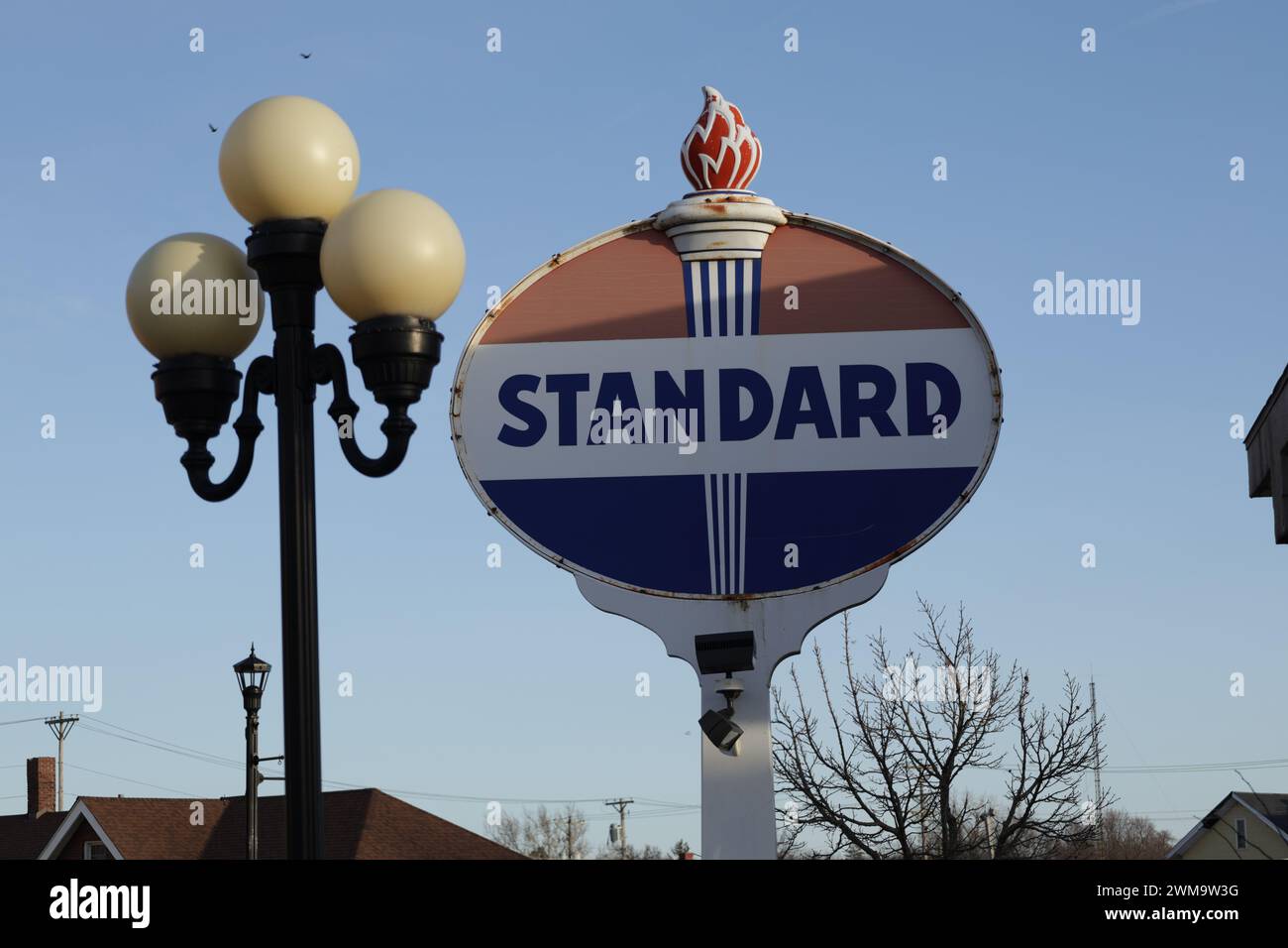 Vintage Tankstellenschild und Straßenlaterne mitten in einer ländlichen Gegend in der Innenstadt. Stockfoto