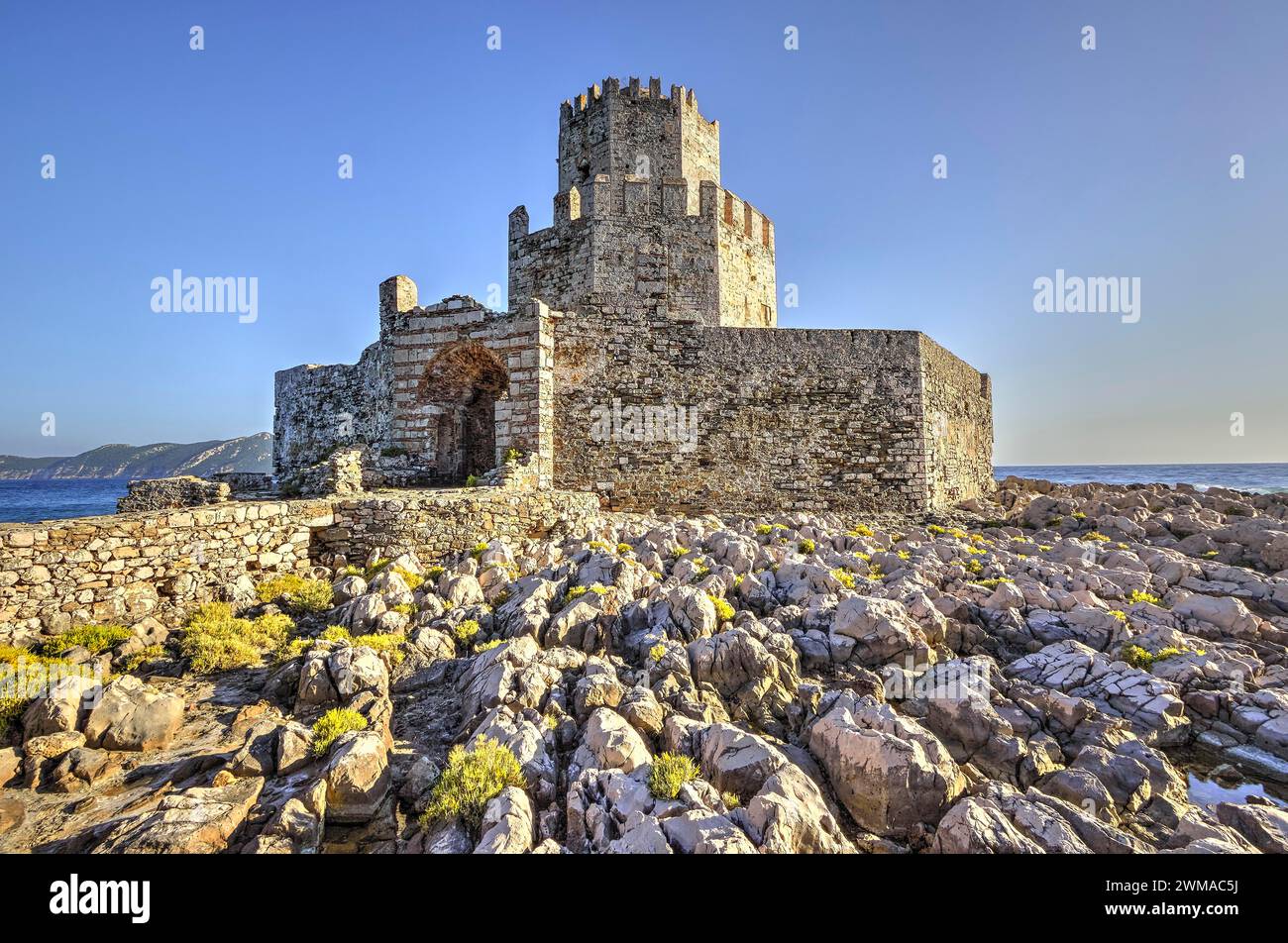 Sonnendurchflutete Burgruinen auf einer felsigen Klippe über dem Meer, achteckiger mittelalterlicher Turm. Die Insel Bourtzi, die Festung Methoni, Peloponnes, Griechenland Stockfoto