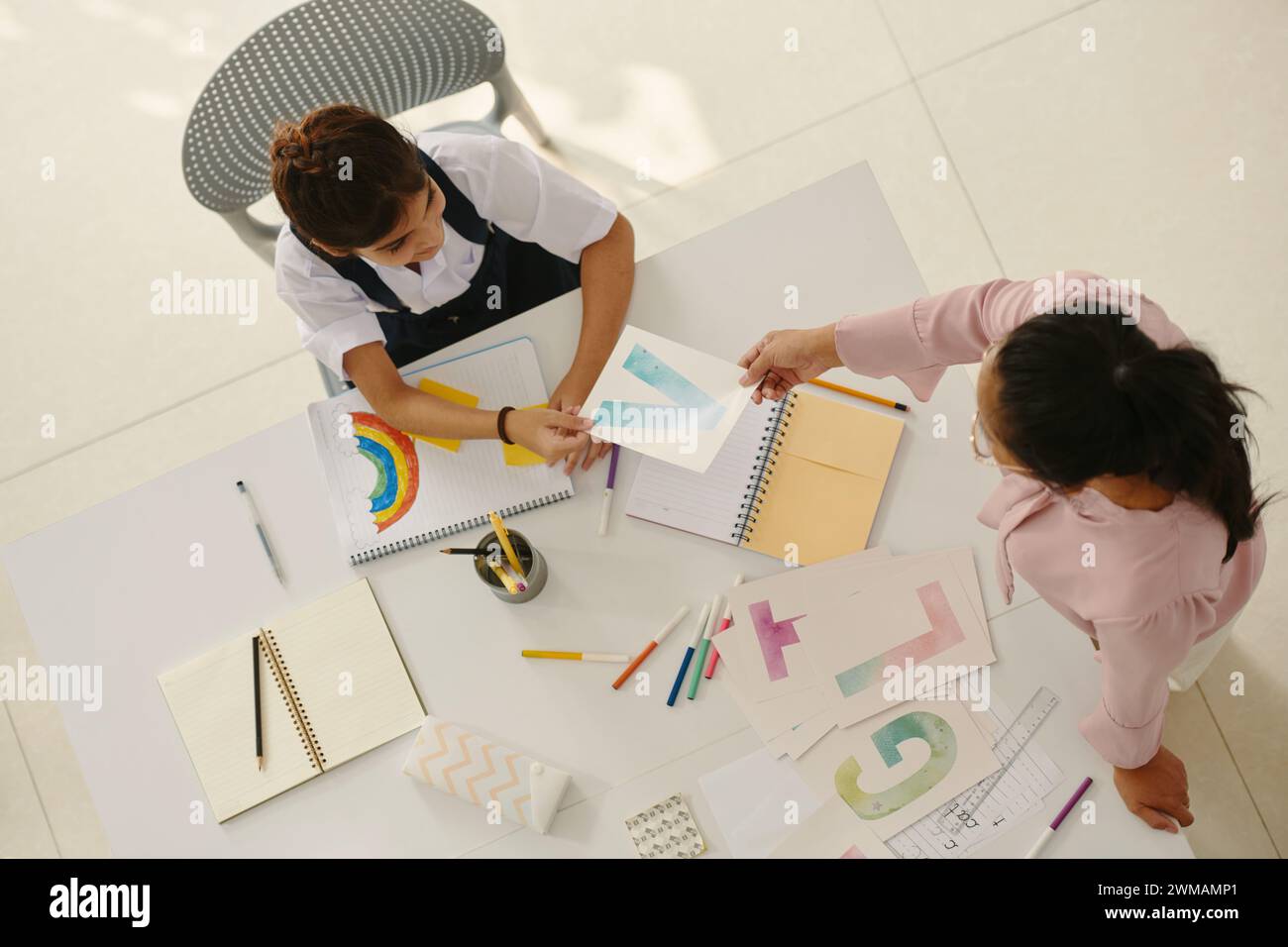 Mädchen lernt Buchstaben des englischen Alphabets mit der Lehrerin Stockfoto