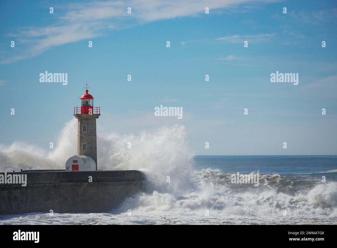 Ein einsamer Leuchtturm erhebt sich inmitten des riesigen Ozeans und führt Schiffe durch die Dunkelheit. Leuchtturm im Meer mit Wolken und Wasser Stockfoto